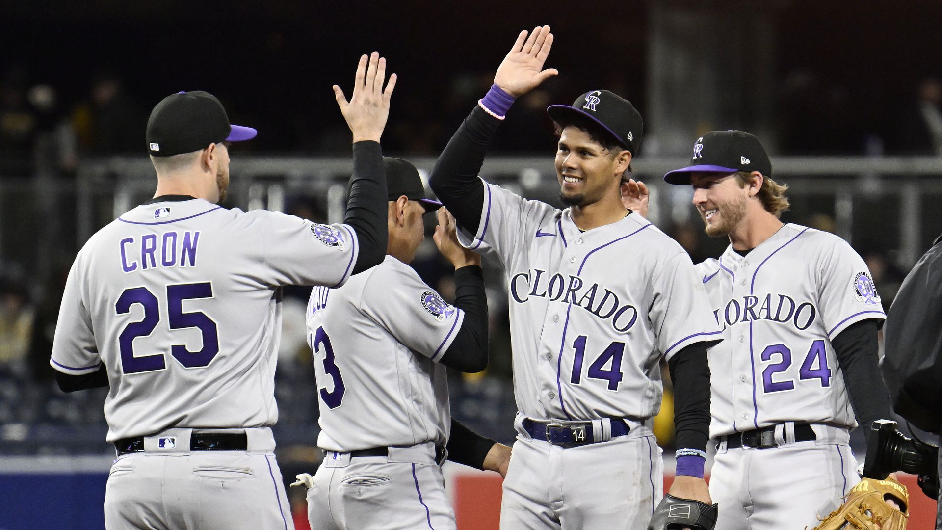 Colorado Rockies players C.J. Cron, Alan Trejo, Ezequiel Tovar and Ryan McMahon high-five.