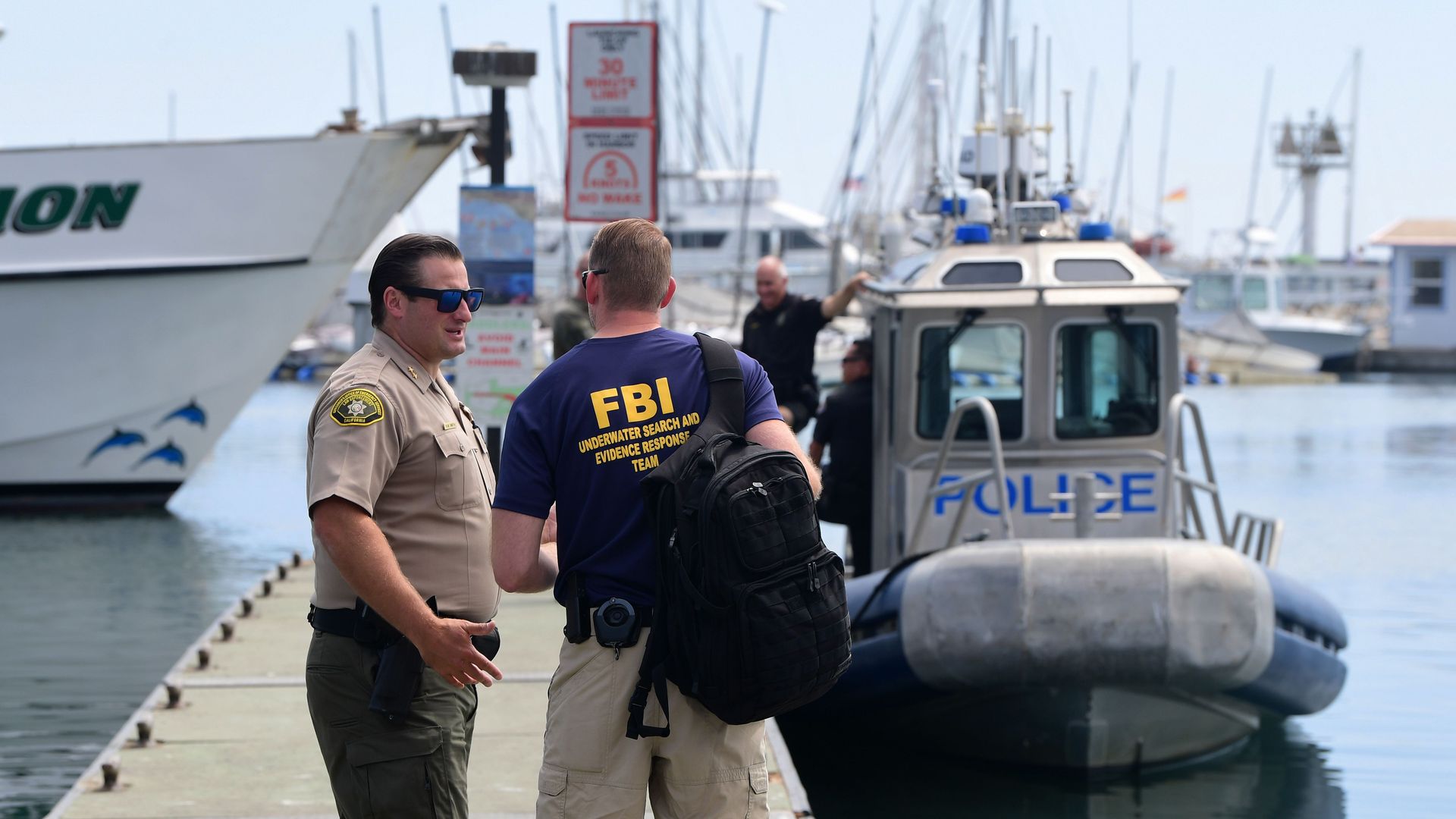 An FBI officer speaking with California police near a Long Beach Police vessel in Santa Barbara, California, in September 2019.