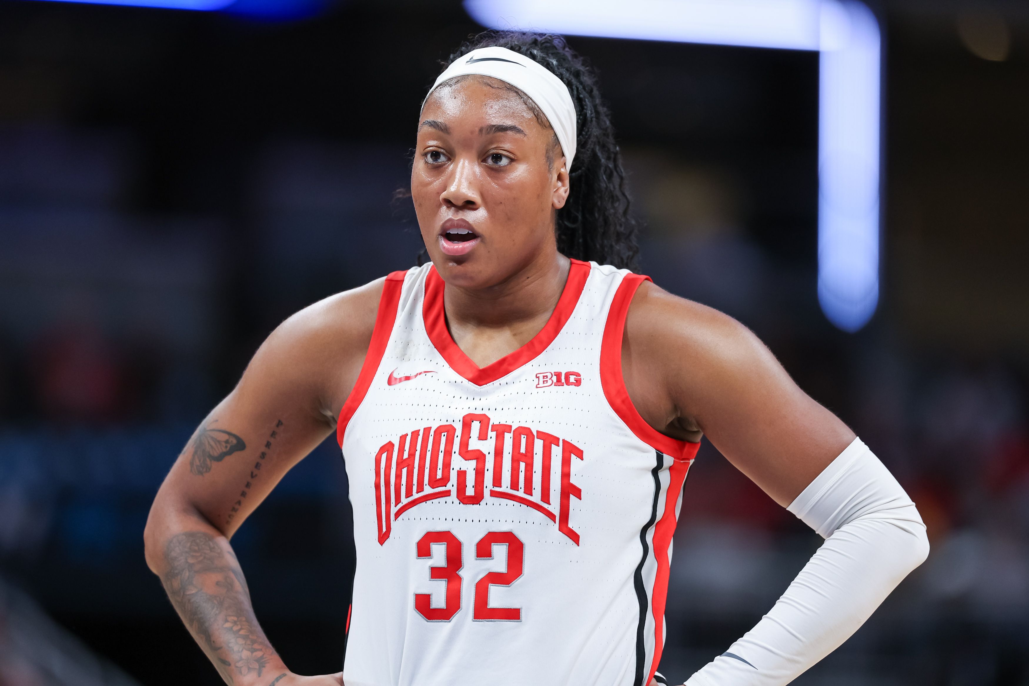 Photo of a woman in a basketball game playing on a court.