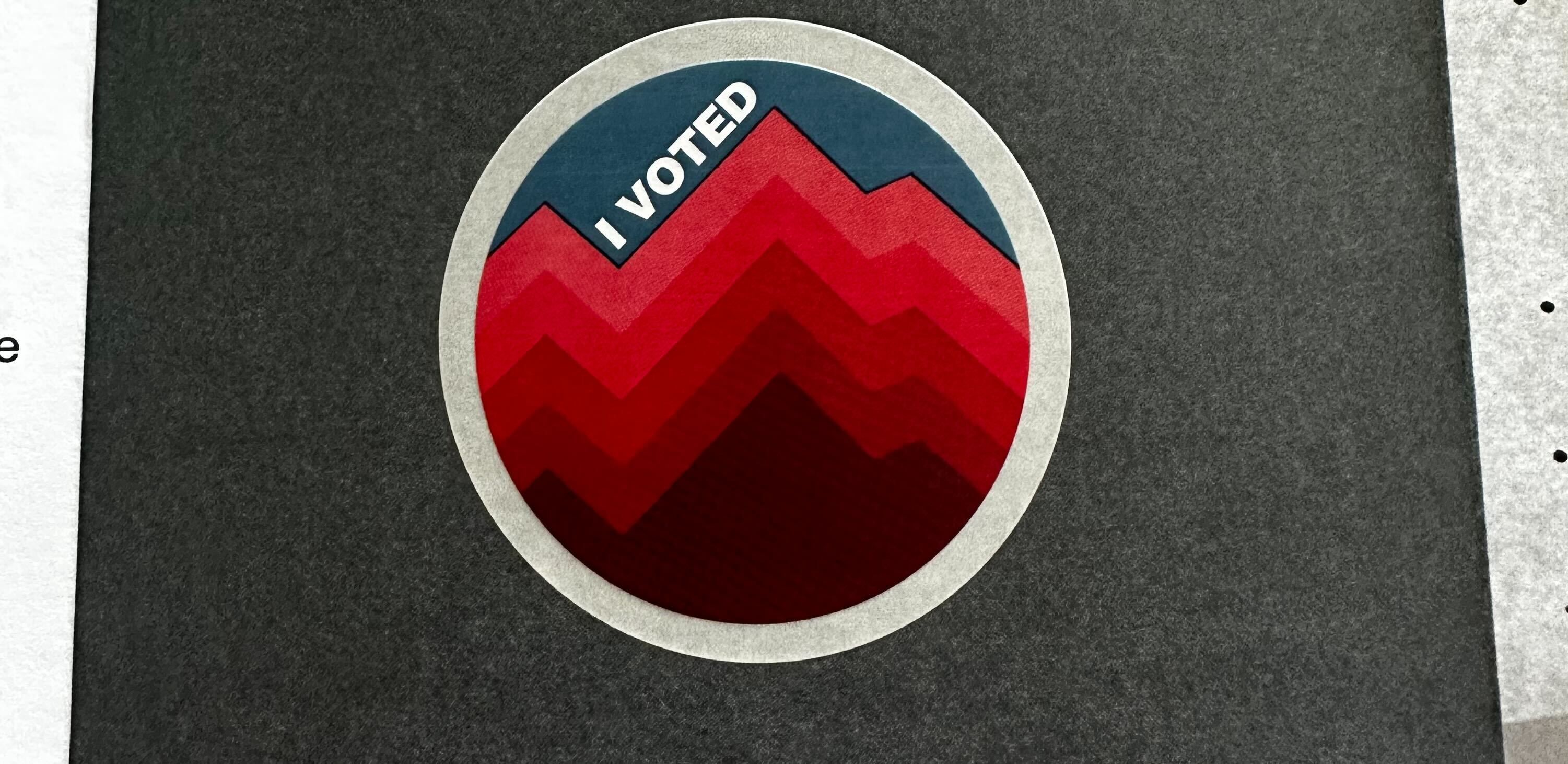 Image shows "I voted" wit red mountains.
