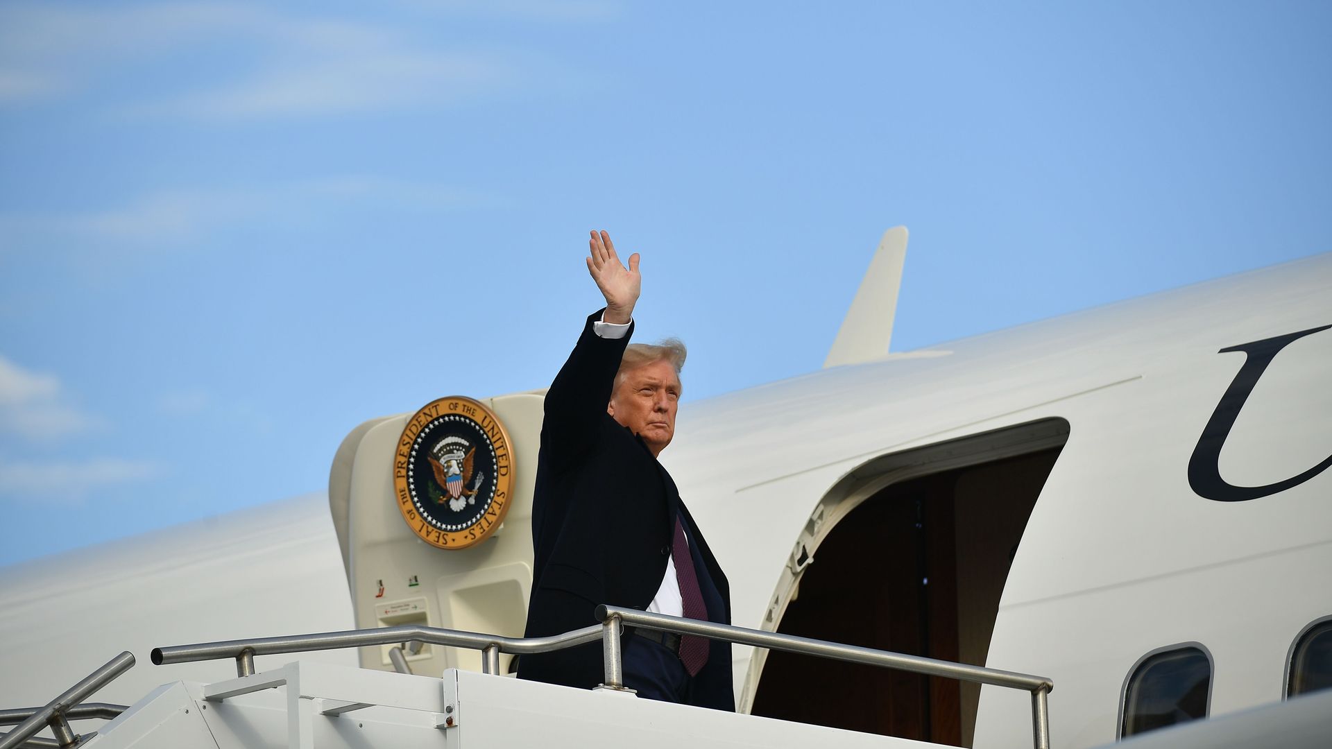 US President Donald Trump waves as he boards Air Force One