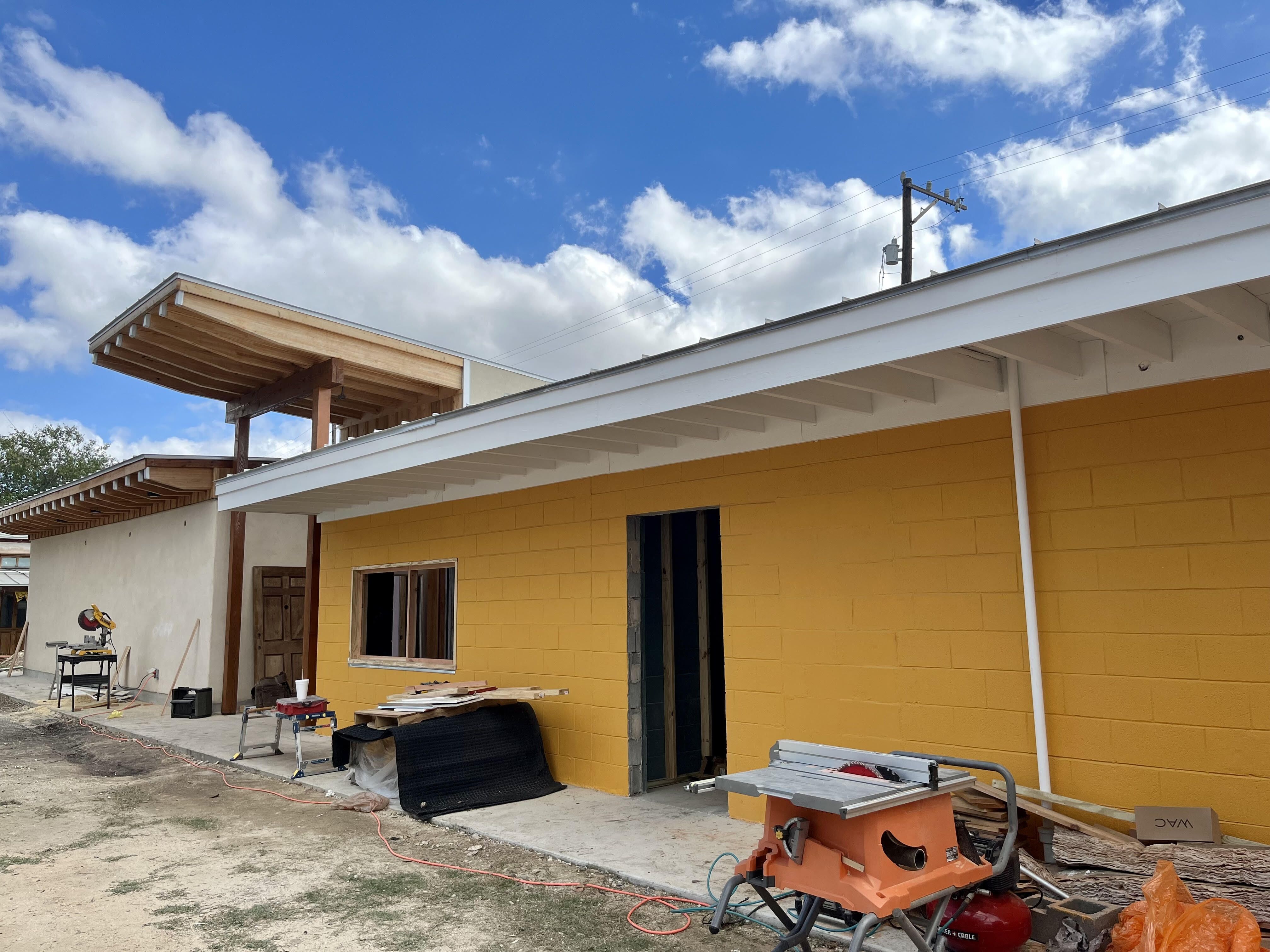 A construction site outside of a yellow brick building. 