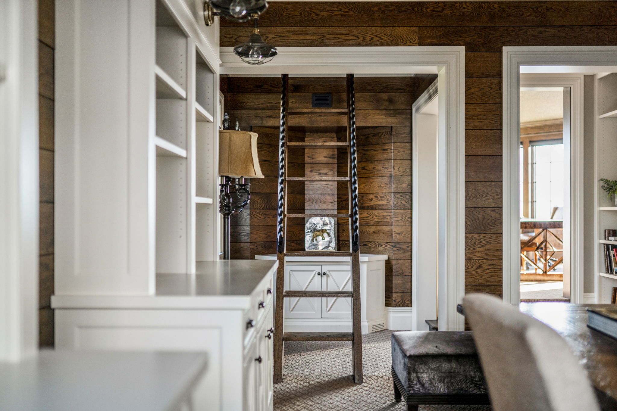 A room with wood walls and a ladder.