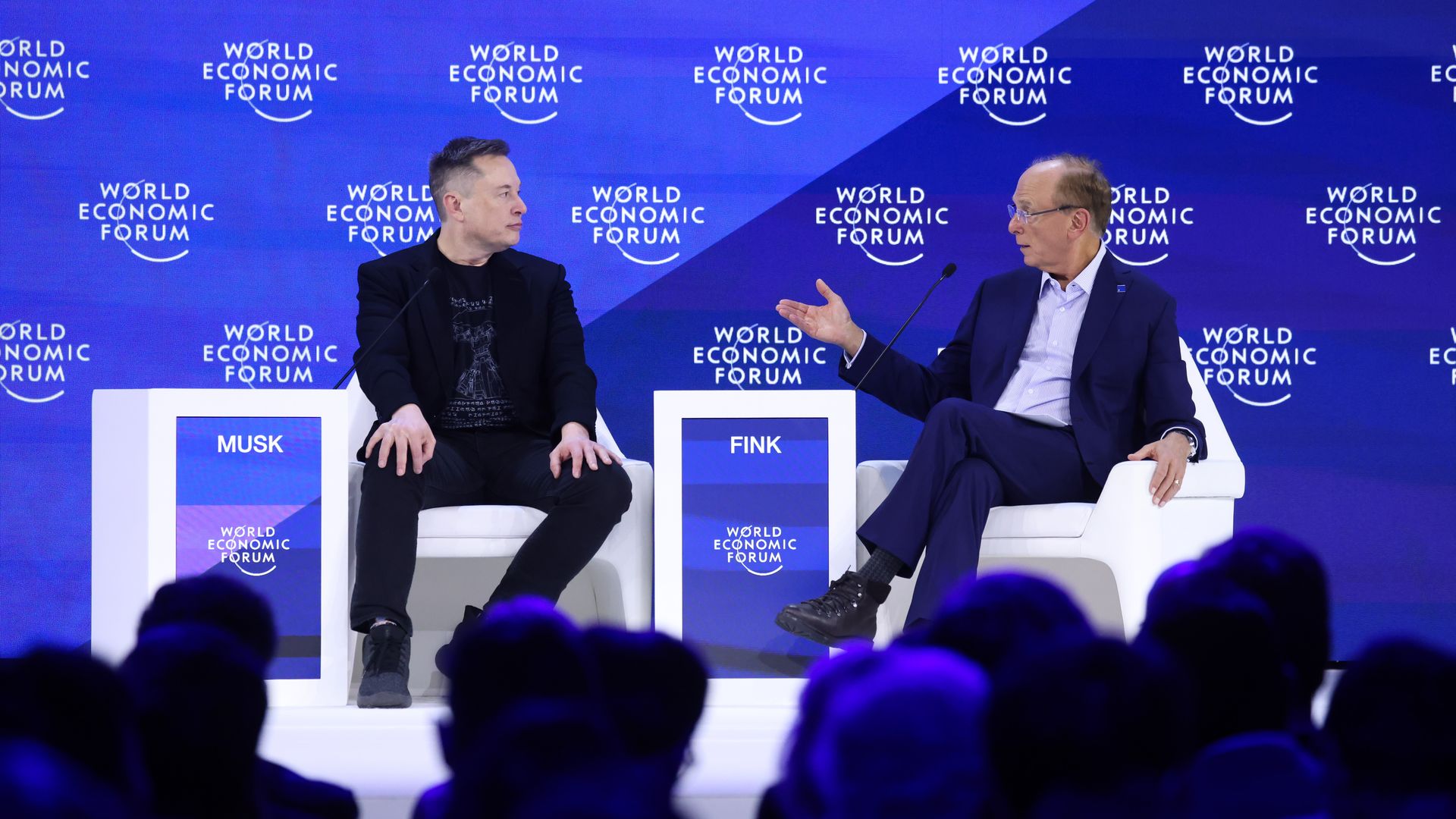 Elon Musk, chief executive officer of Tesla Inc., left, and Larry Fink, chief executive officer of BlackRock Inc., during the World Economic Forum (WEF) in Davos, Switzerland, on Thursday, Jan. 22, 2026. 