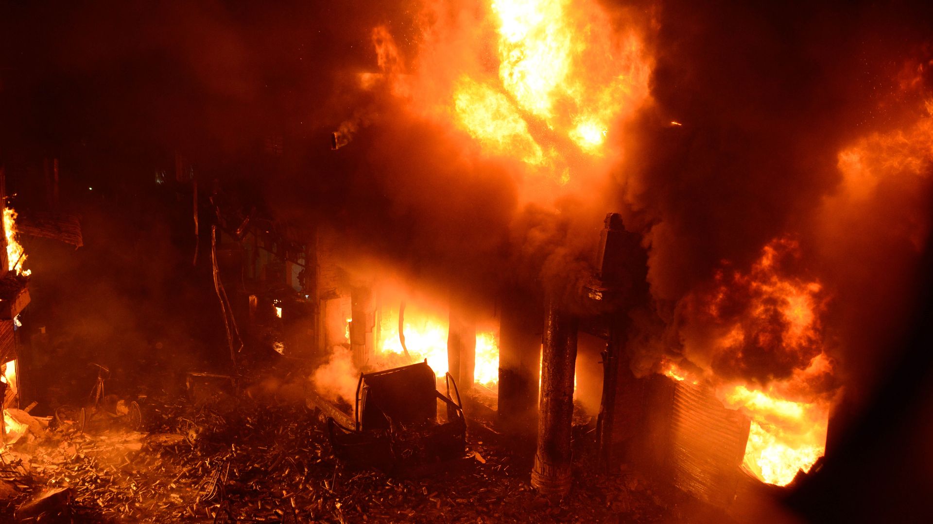 In this image, a fire takes over a home and is visible in every window and door.