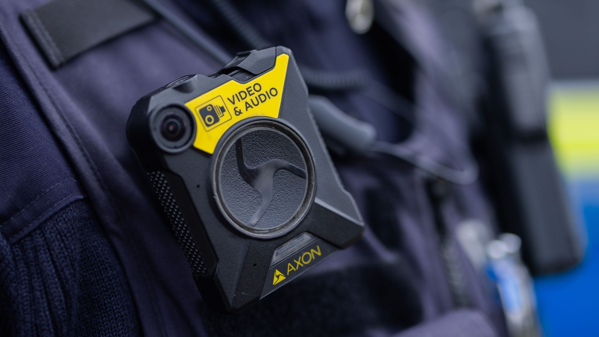 A close-up photo of an Axon audio and video recording device attached to a police officer's chest.