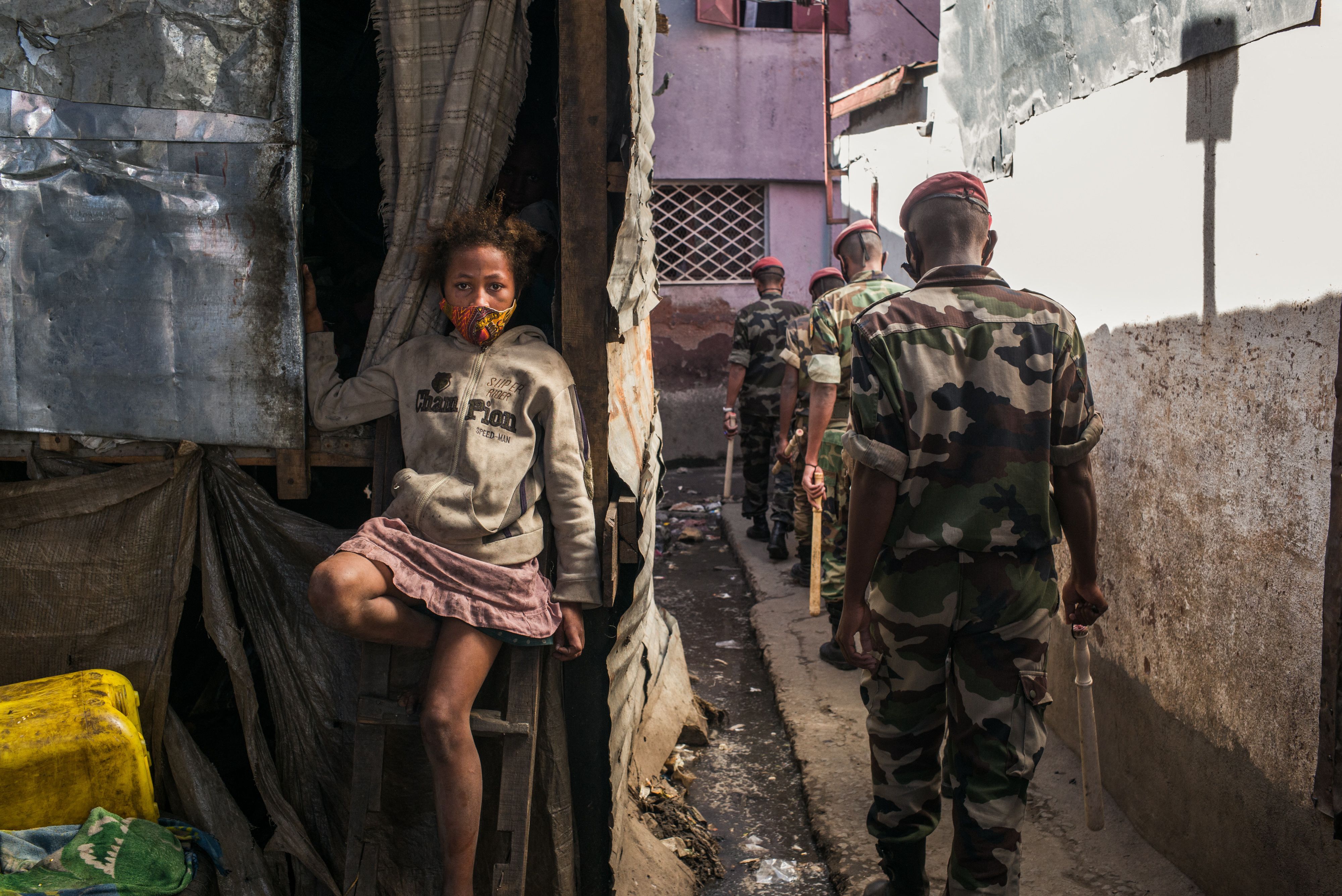 A child sits as members of the army patrol the streets of Antananarivo ordering citizens to go home as the Malagasy authorities declared a total weekend lockdown in the capital on April 24
