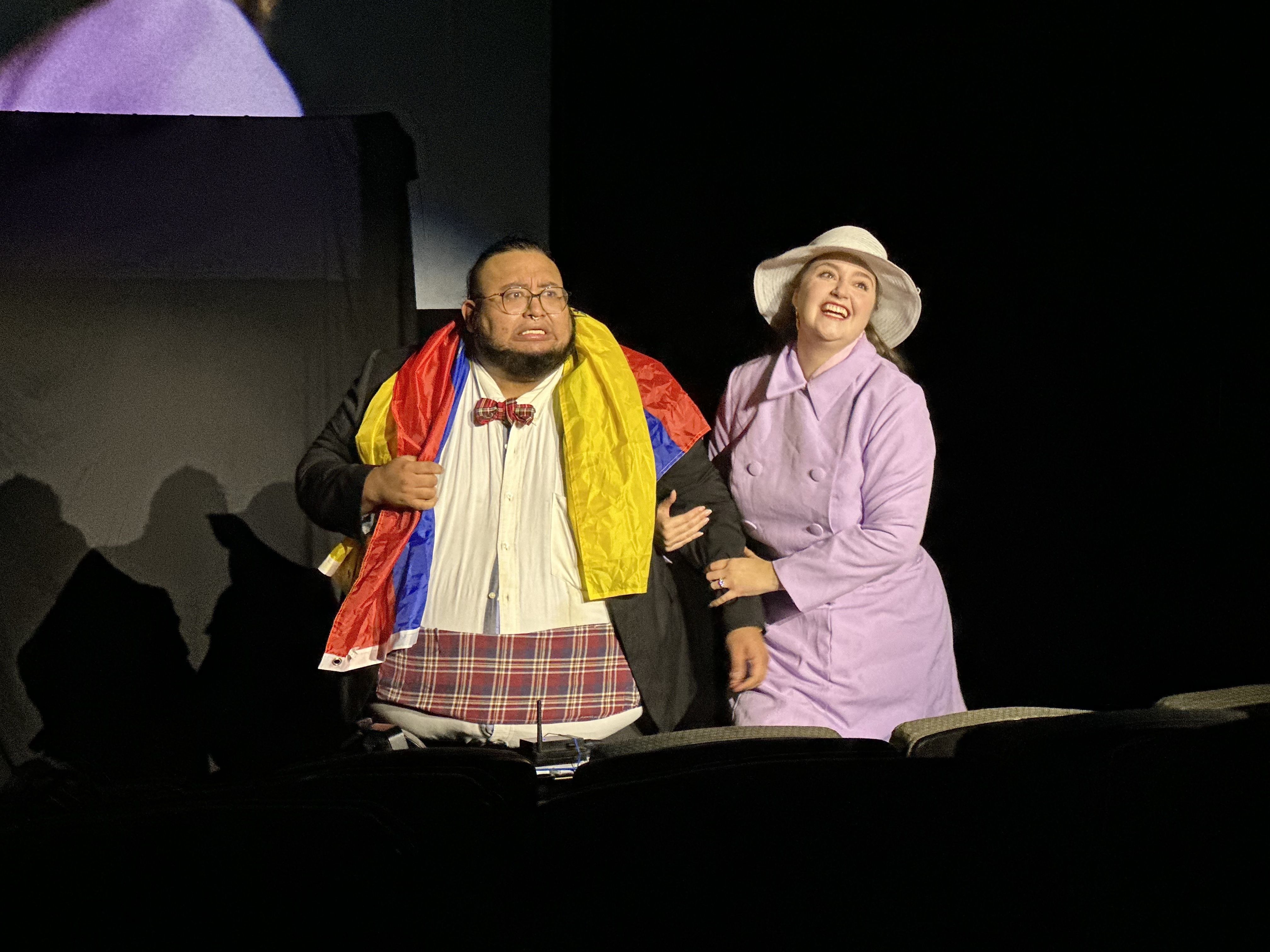 Latine actors playing Brad Majors and Janet Weiss in a first-ever Hispanic Heritage Month performance of Boston's "Rocky Horror Picture Show." Brad has an Ecuadorian flag drapped over them.