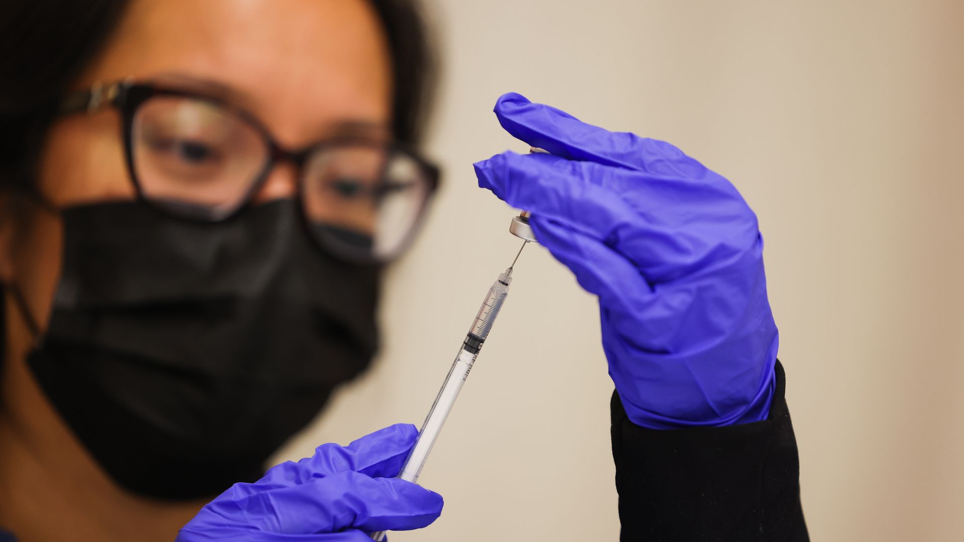 A nurse practitioner prepares a COVID booster.