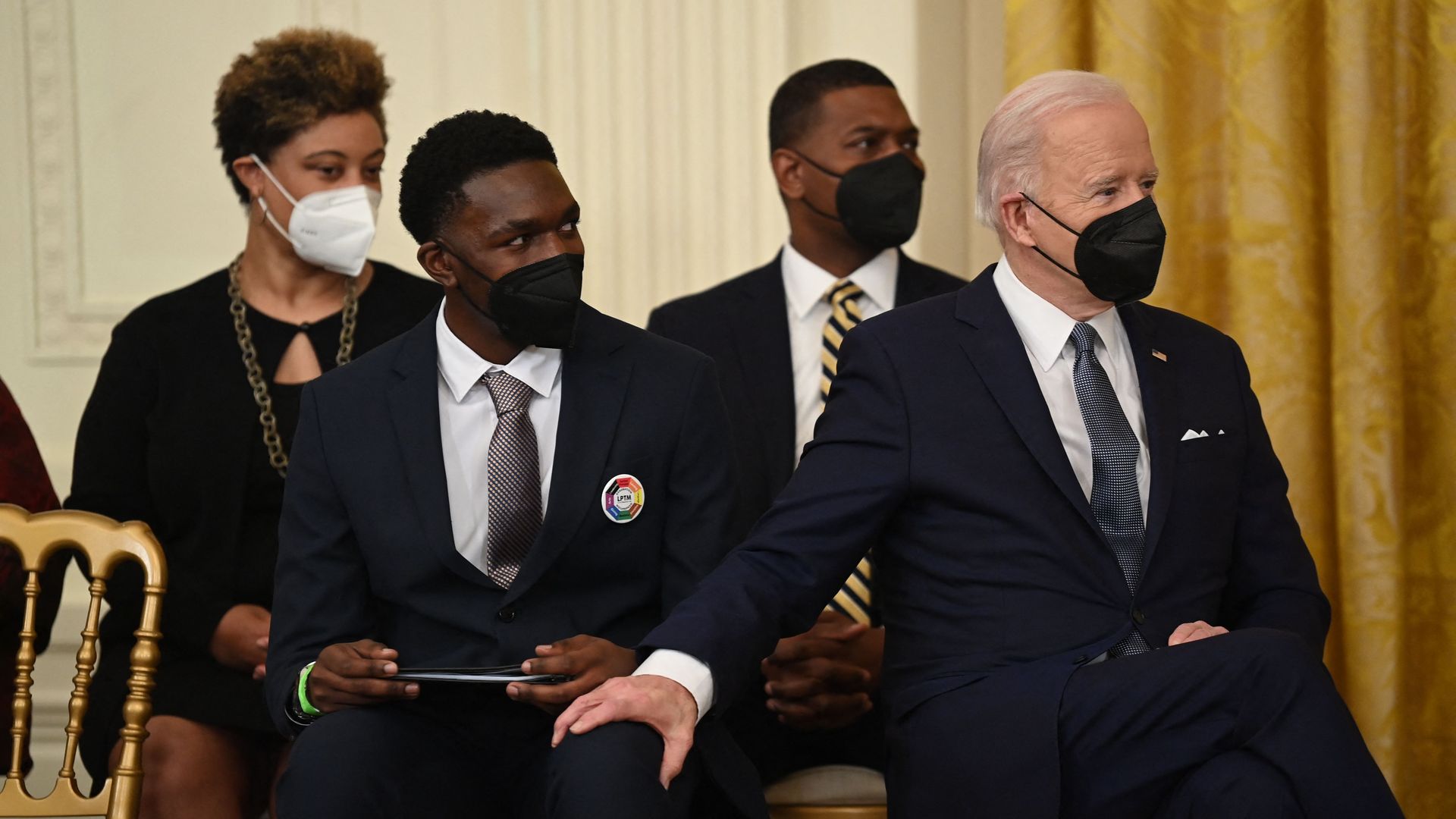 President Biden is seen grabbing the knee of a student being honored at a White House event to close out Black History Month.
