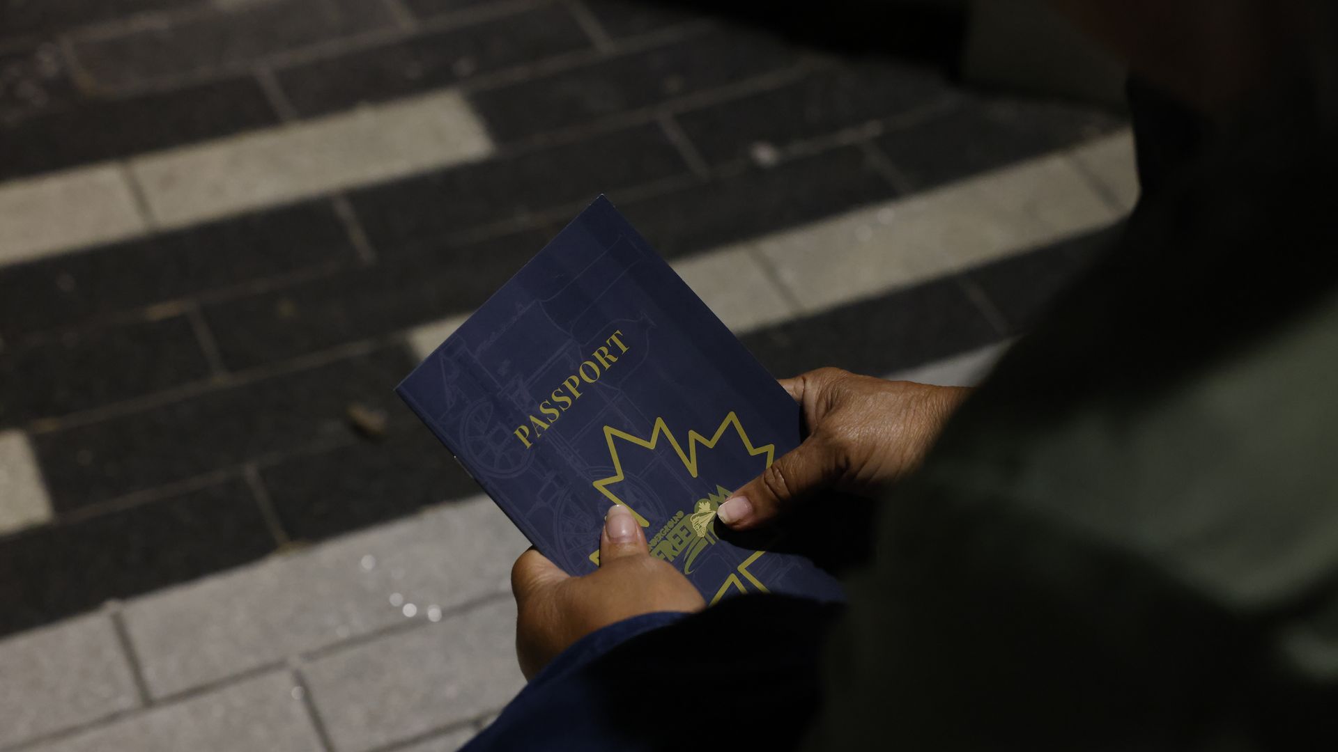 Two hands hold a Canadian passport