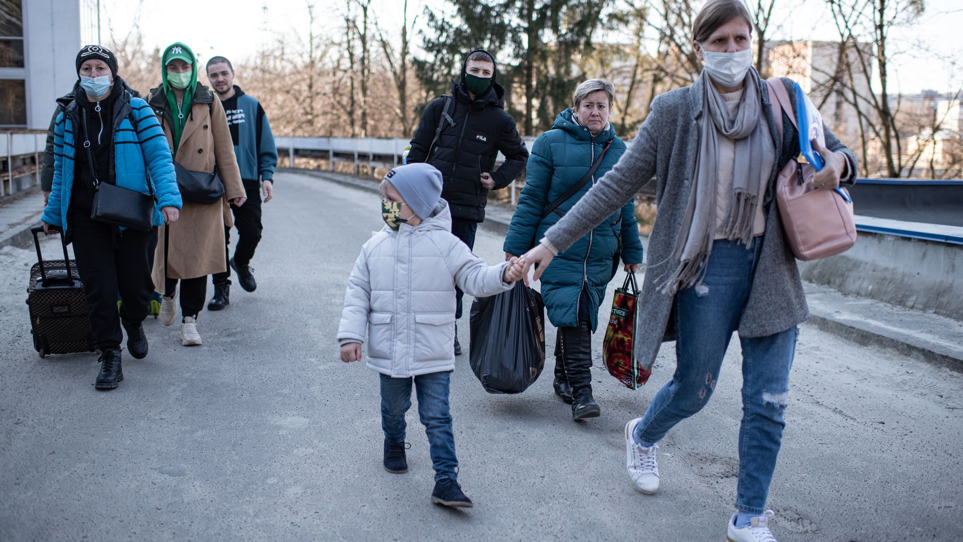 A woman and her son walk from Lviv Regional Childrens Specialized Clinical Hospital to the buses before being evacuated to Poland in Lviv, Ukraine.