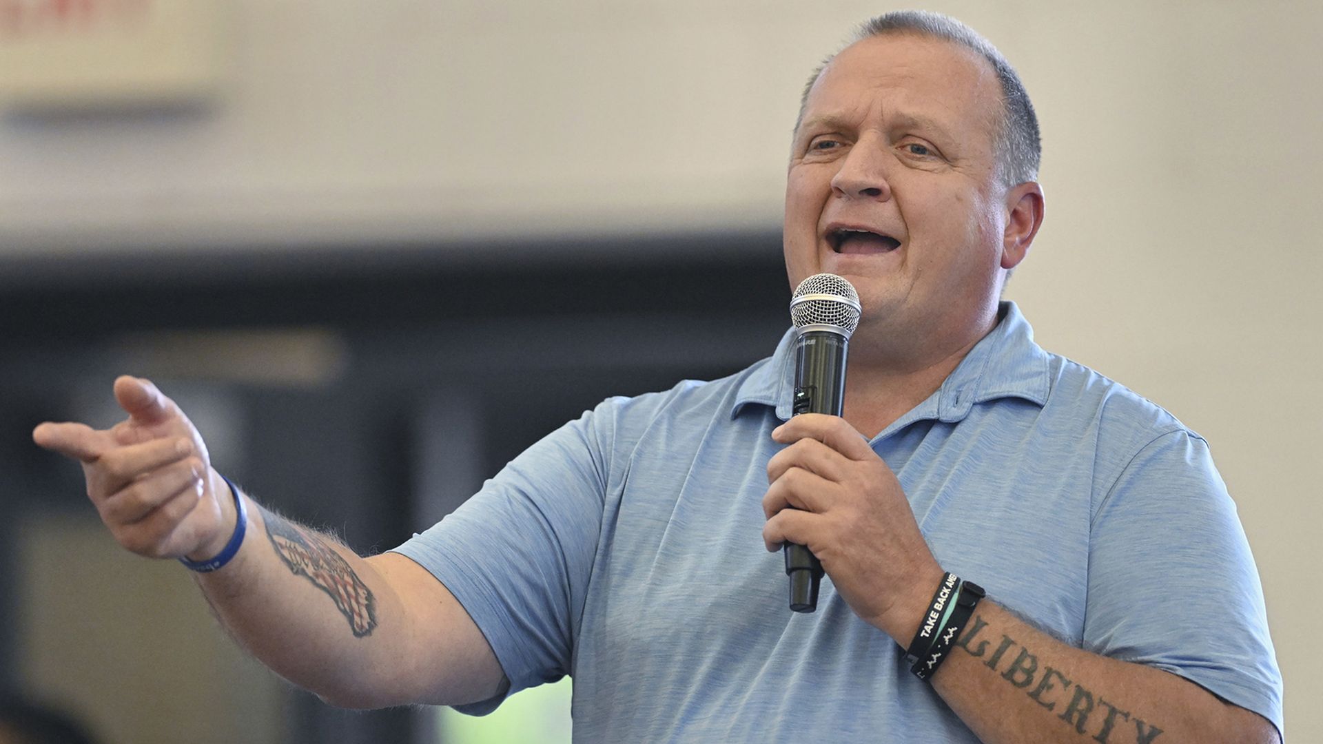 Photo of a man speaking into a microphone 