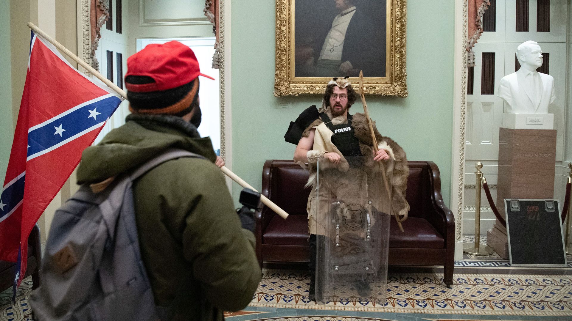 A man is seen carrying a Confederate flag outside the Senate Chamber after the Capitol was stormed Wednesday.