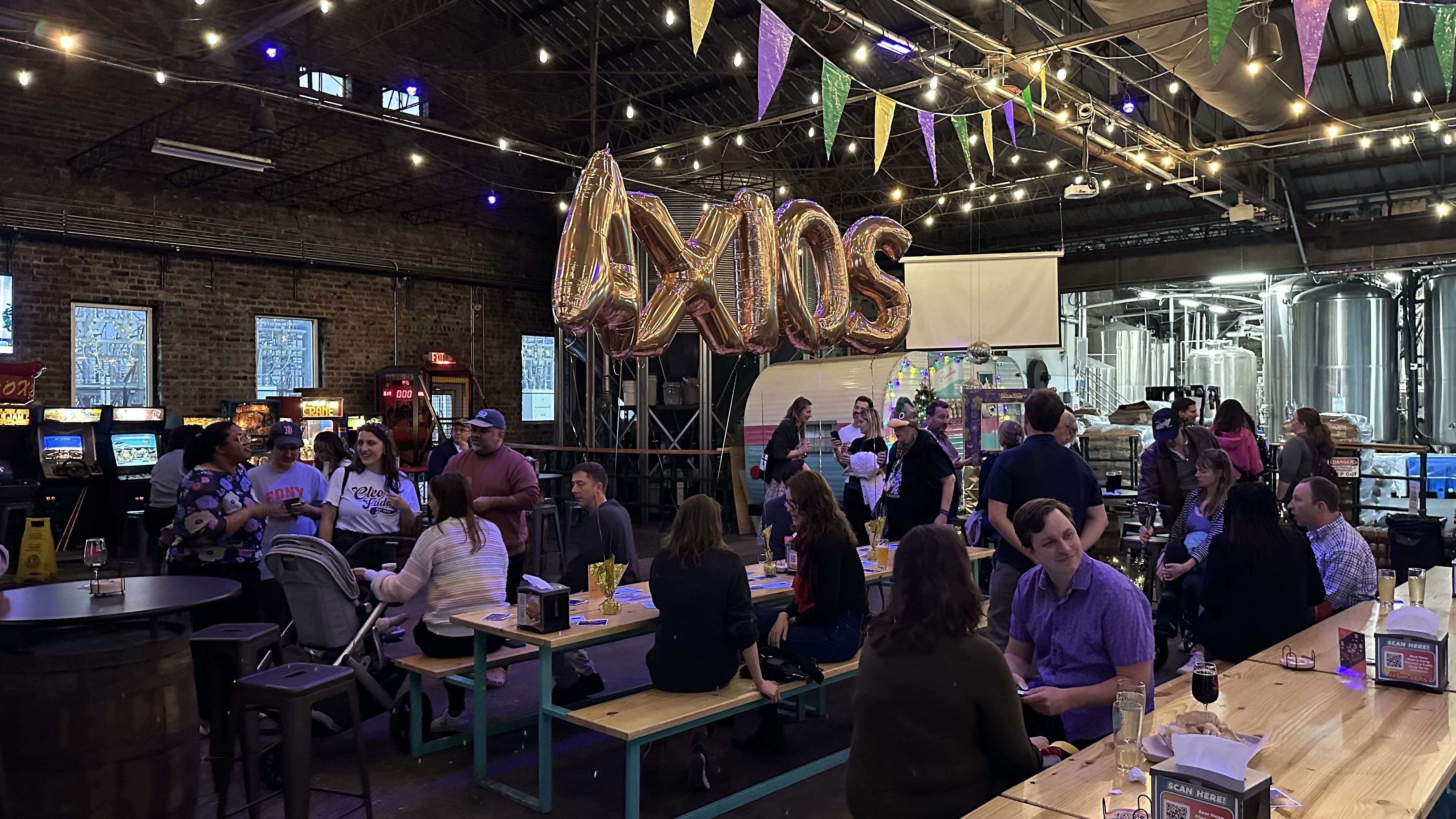 A scenic shot of Urban South, which is crowded as people hang out underneath balloons that say AXIOS.