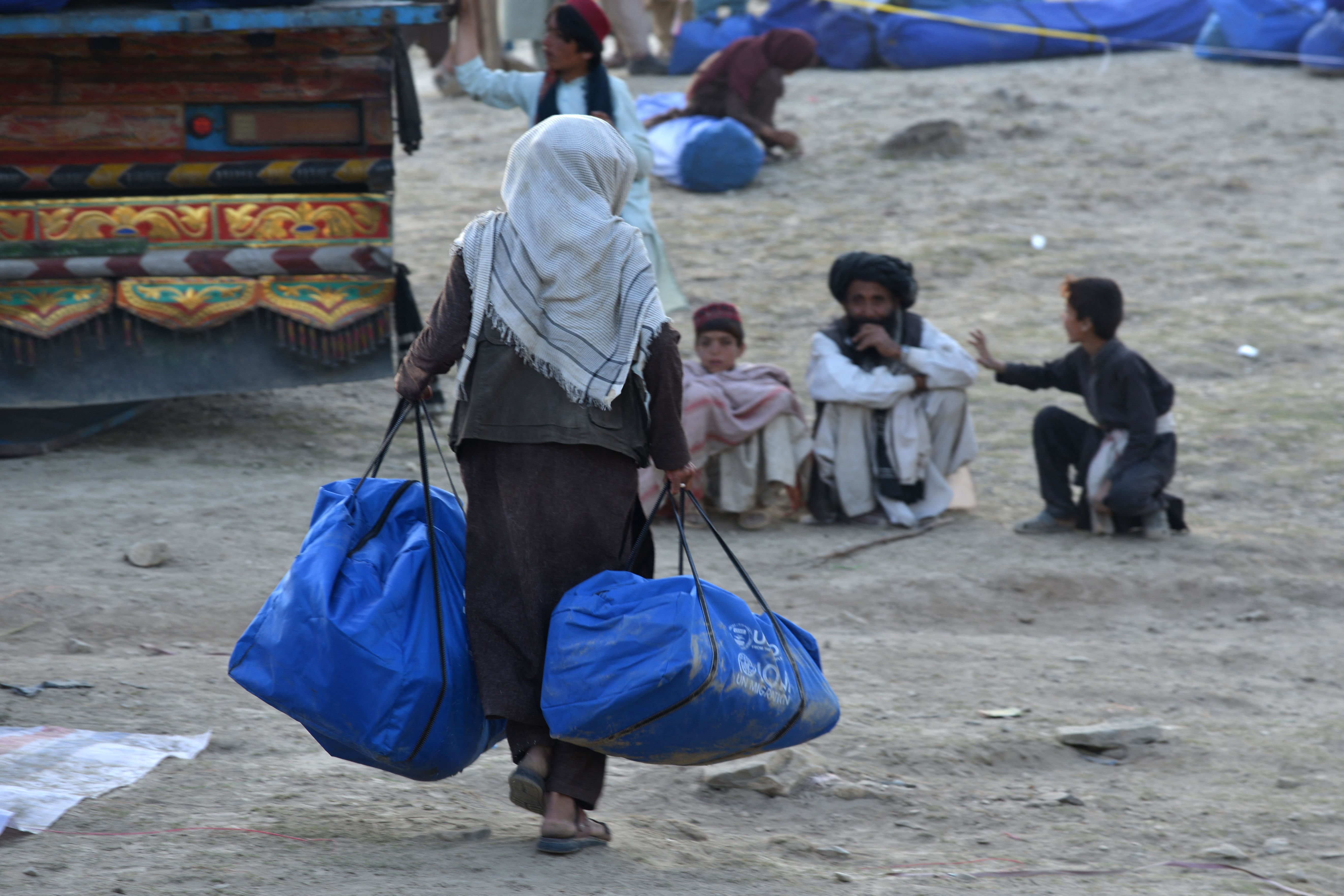 2, a volunteer carries aid being received from the International Organization for Migration (IOM) for recent earthquake affected people in the Afghan-Dubai village of Spera district in Khost province