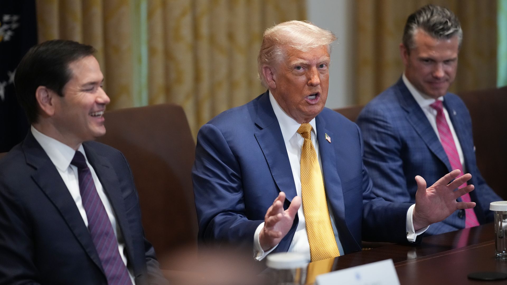 Donald Trump sitting at a cabinet meeting table