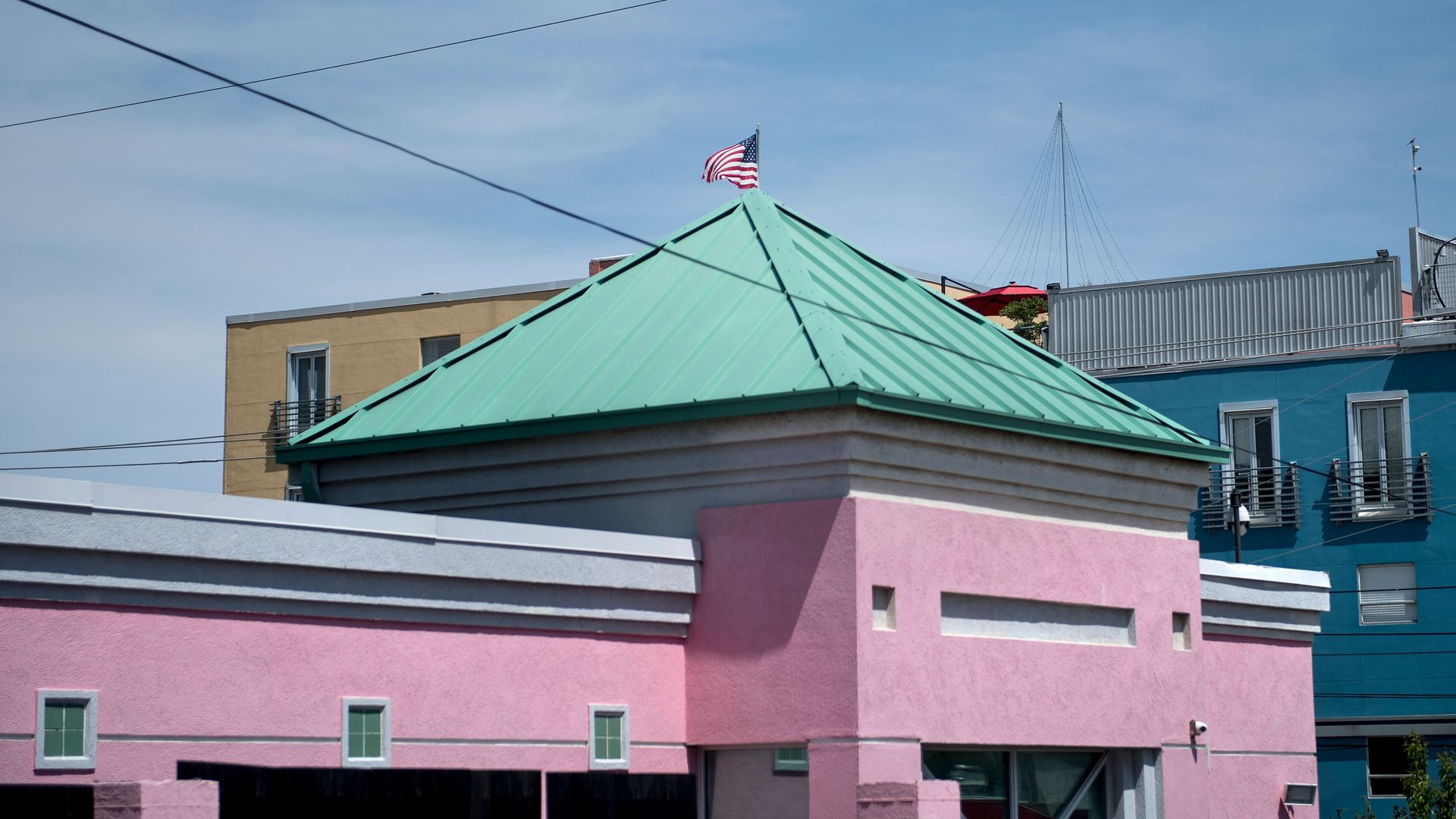 Picture of a pink building with a green roof