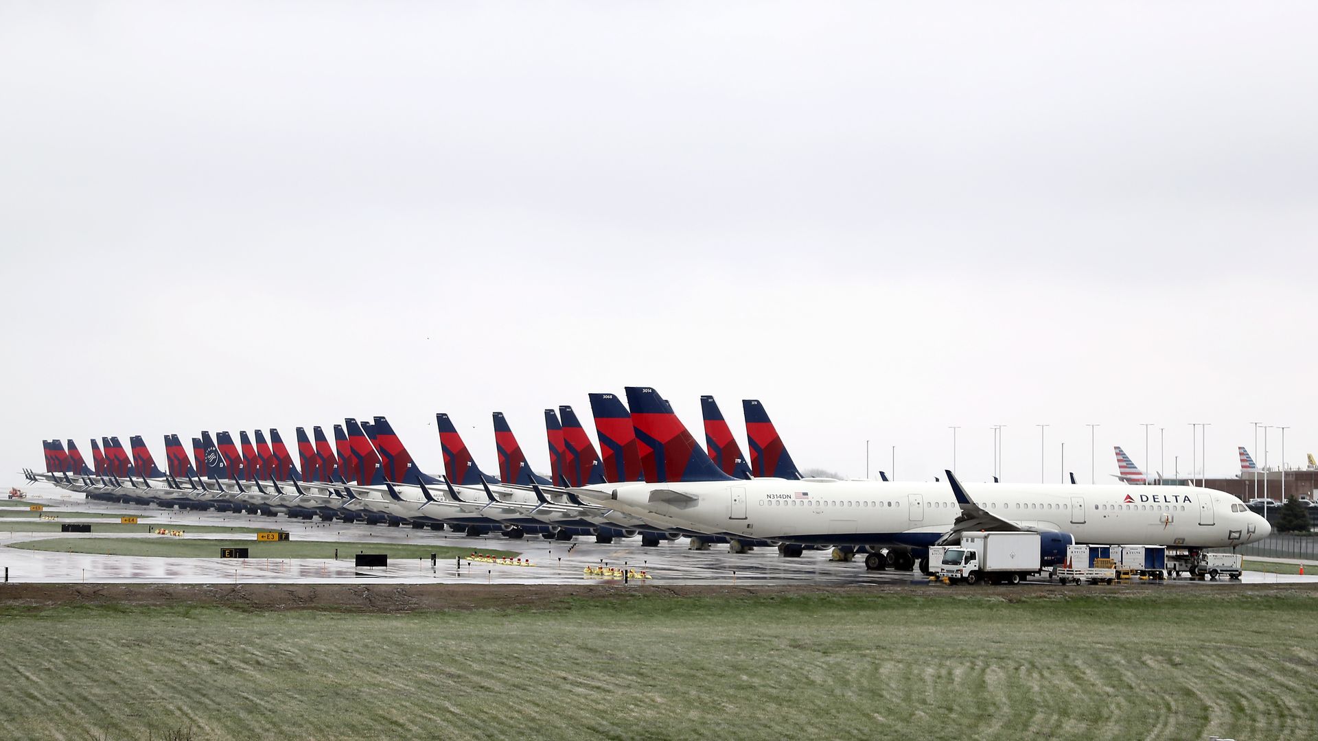 In this image, a row of airplanes sit idly 