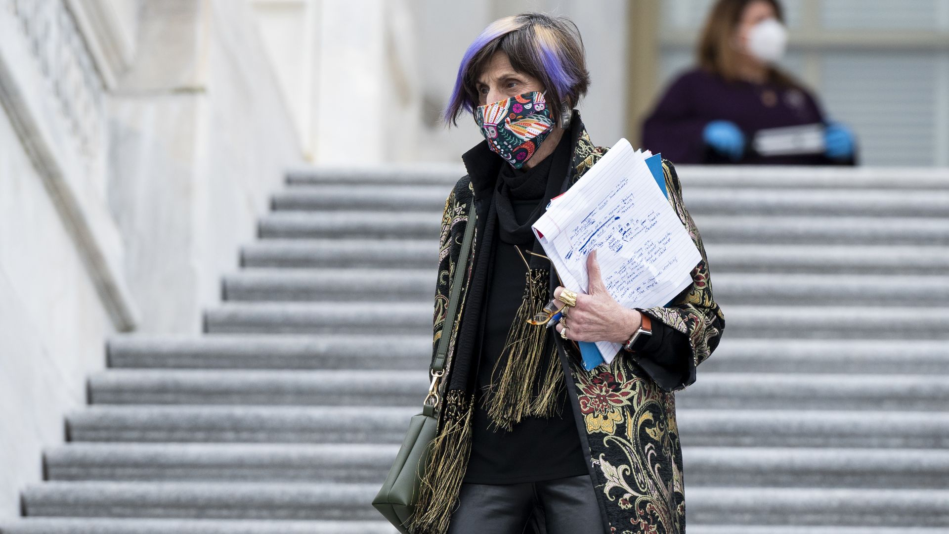 Rep. Rosa De Lauro walks down stairs while holding papers