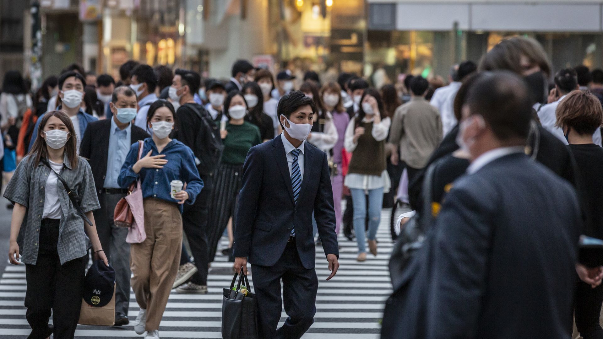 People wearing face masks while crossing a street in Tokyo on May 28.