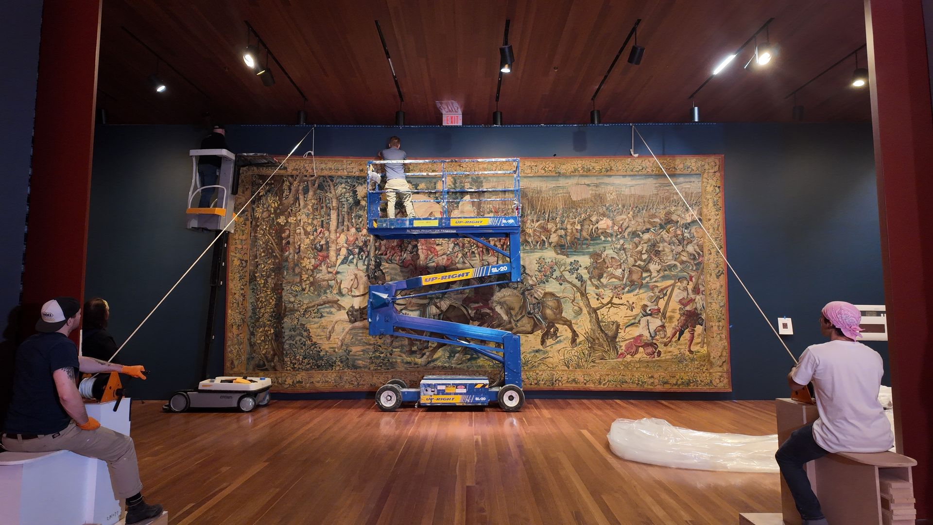 Photo of a huge canvas being set up in a large gallery room
