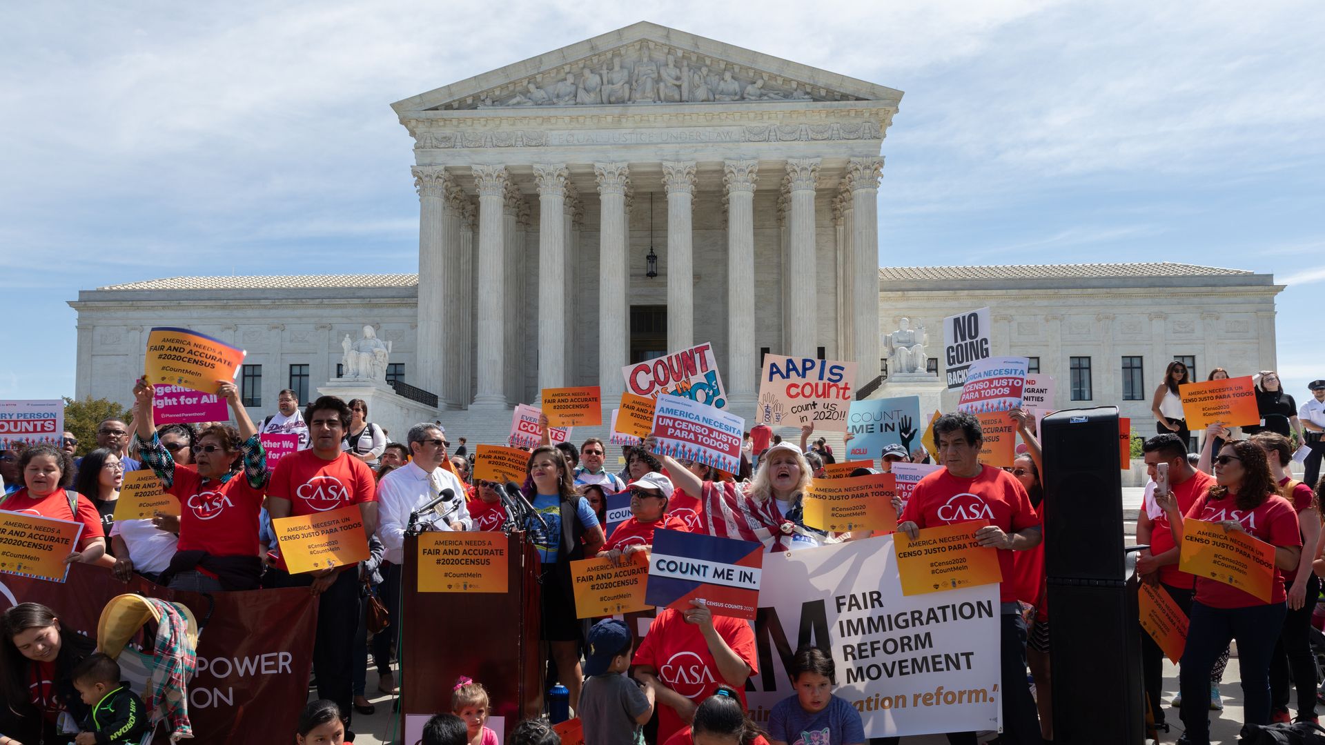 Protesters in front of the U.S. Supreme Court, holding sings opposing Trump immigration policy.