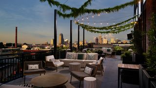 A rooftop terrace at night in front of Atlanta skyline