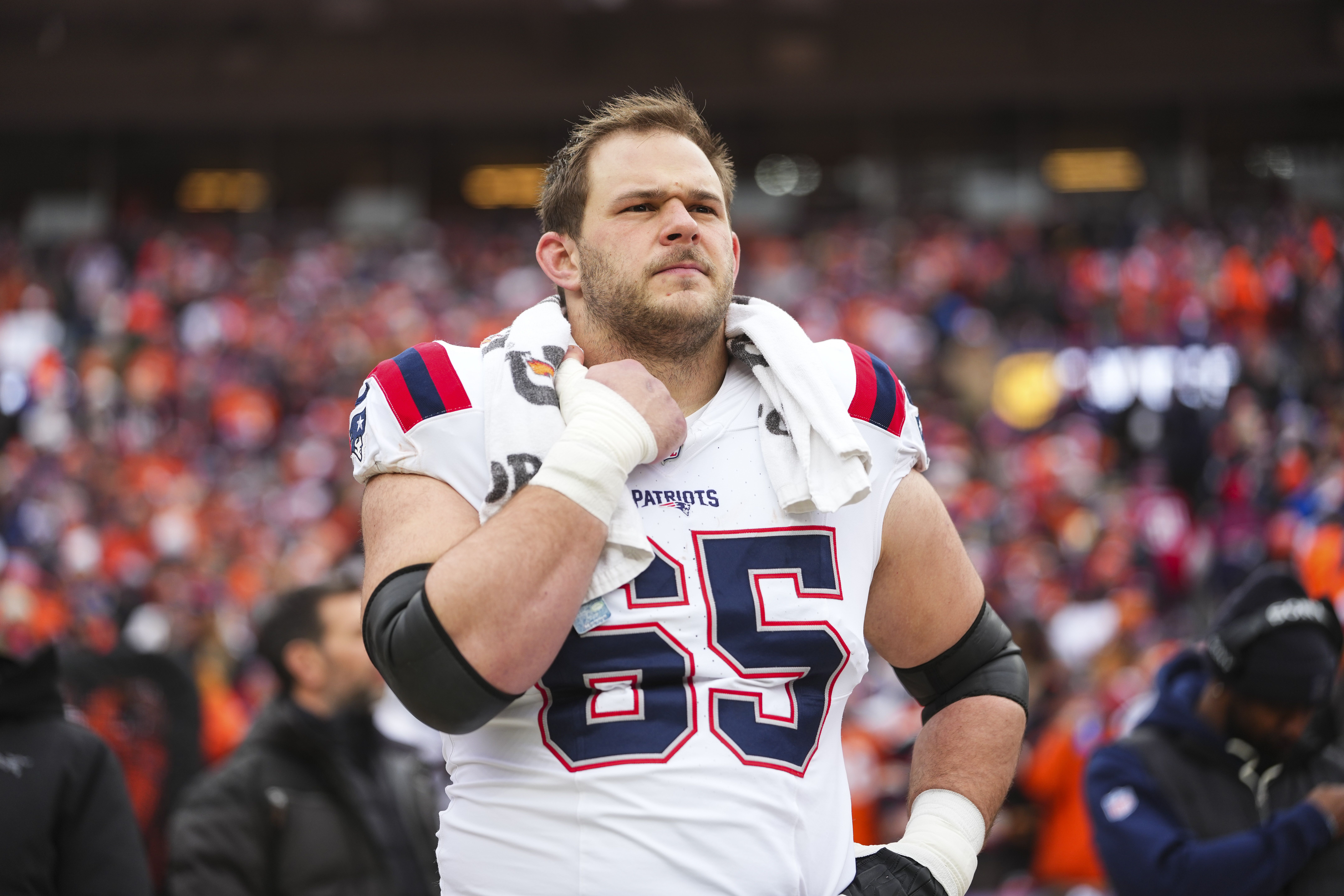 Garrett Bradbury #65 of the New England Patriots looks on from the sideline during the national anthem prior to the AFC Championship NFL football game against the Denver Broncos at Empower Field At Mile High on January 25, 2026 in Denver, Colorado. (Photo by Cooper Neill/Getty Images