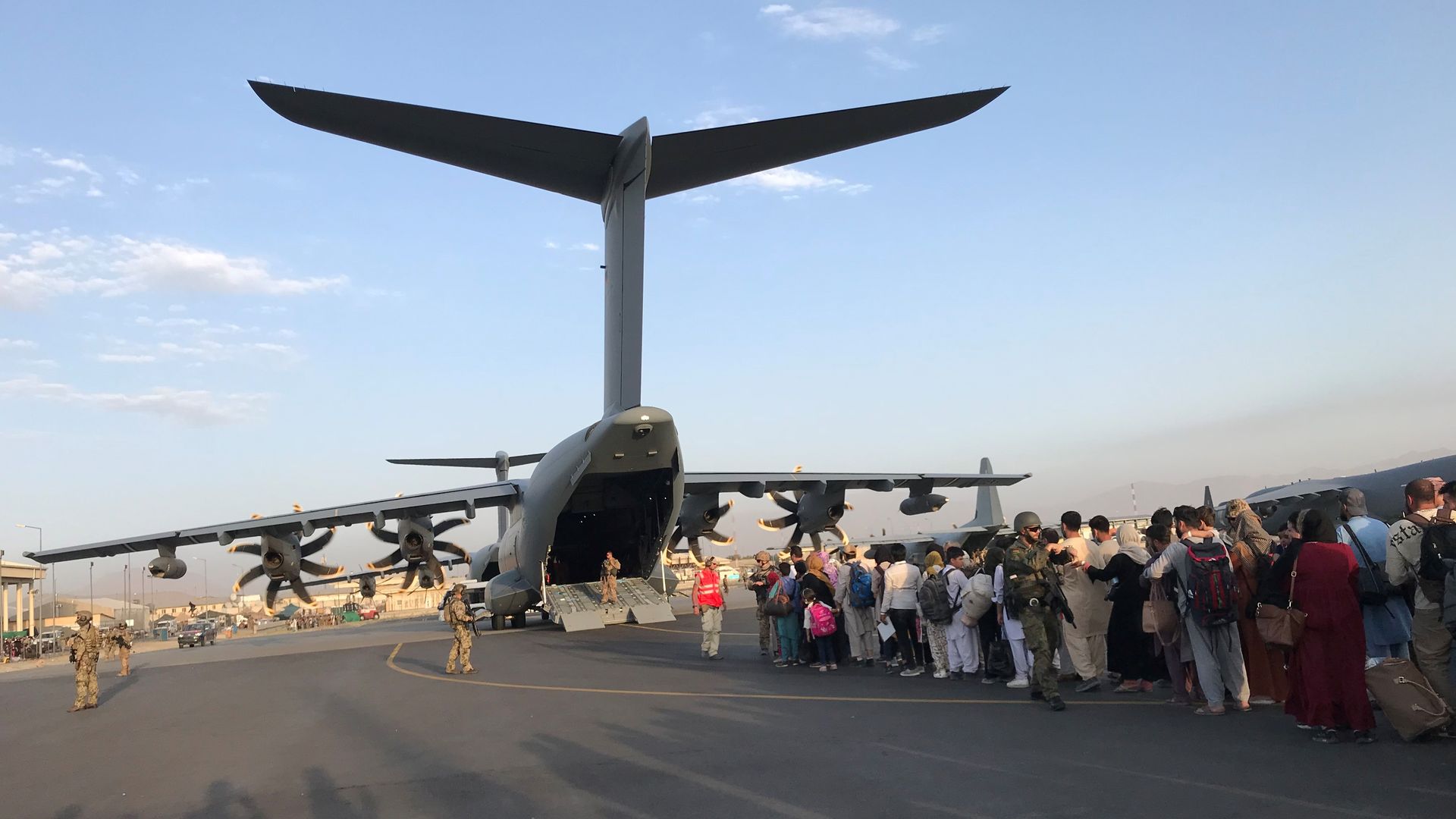 Afghans are seen lining up to board a German transport plane to flee Kabul in late August.