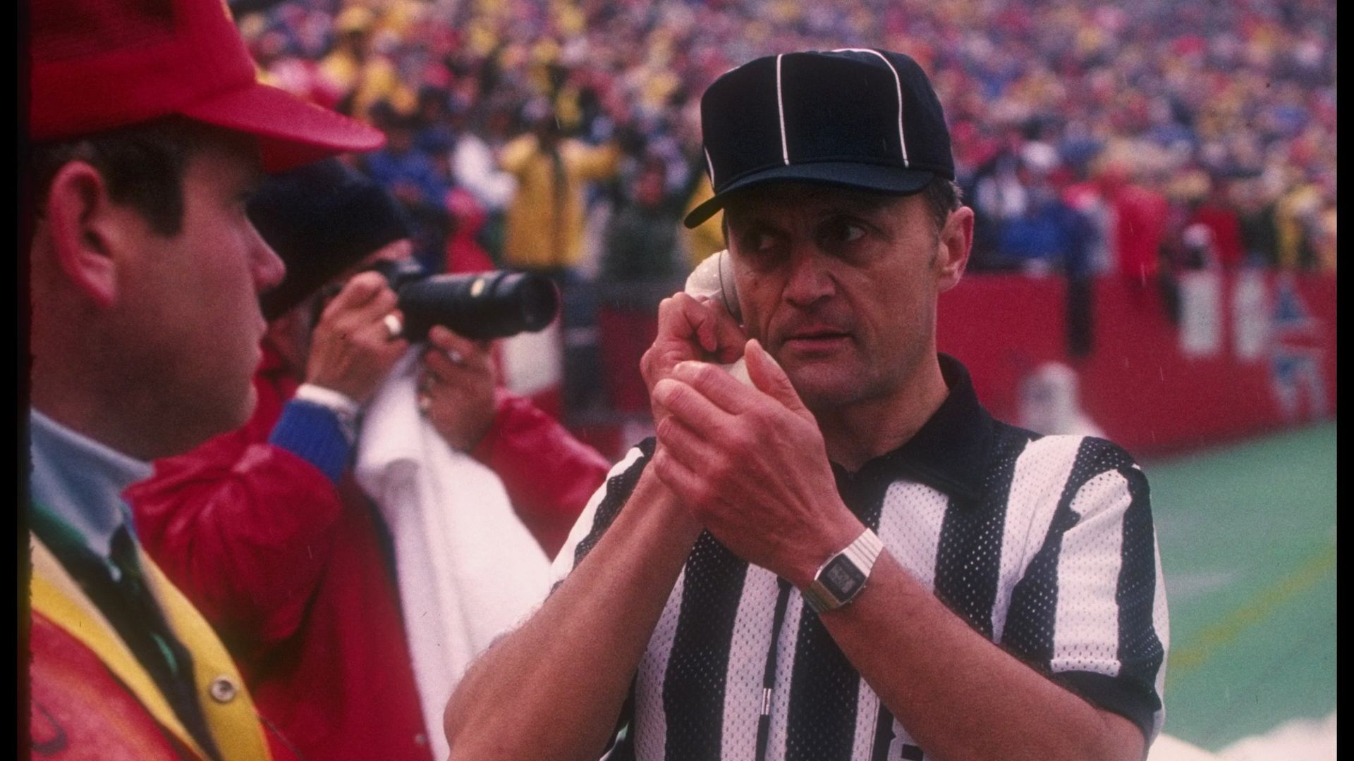 An NFL official waiting on word from the replay booth upstairs