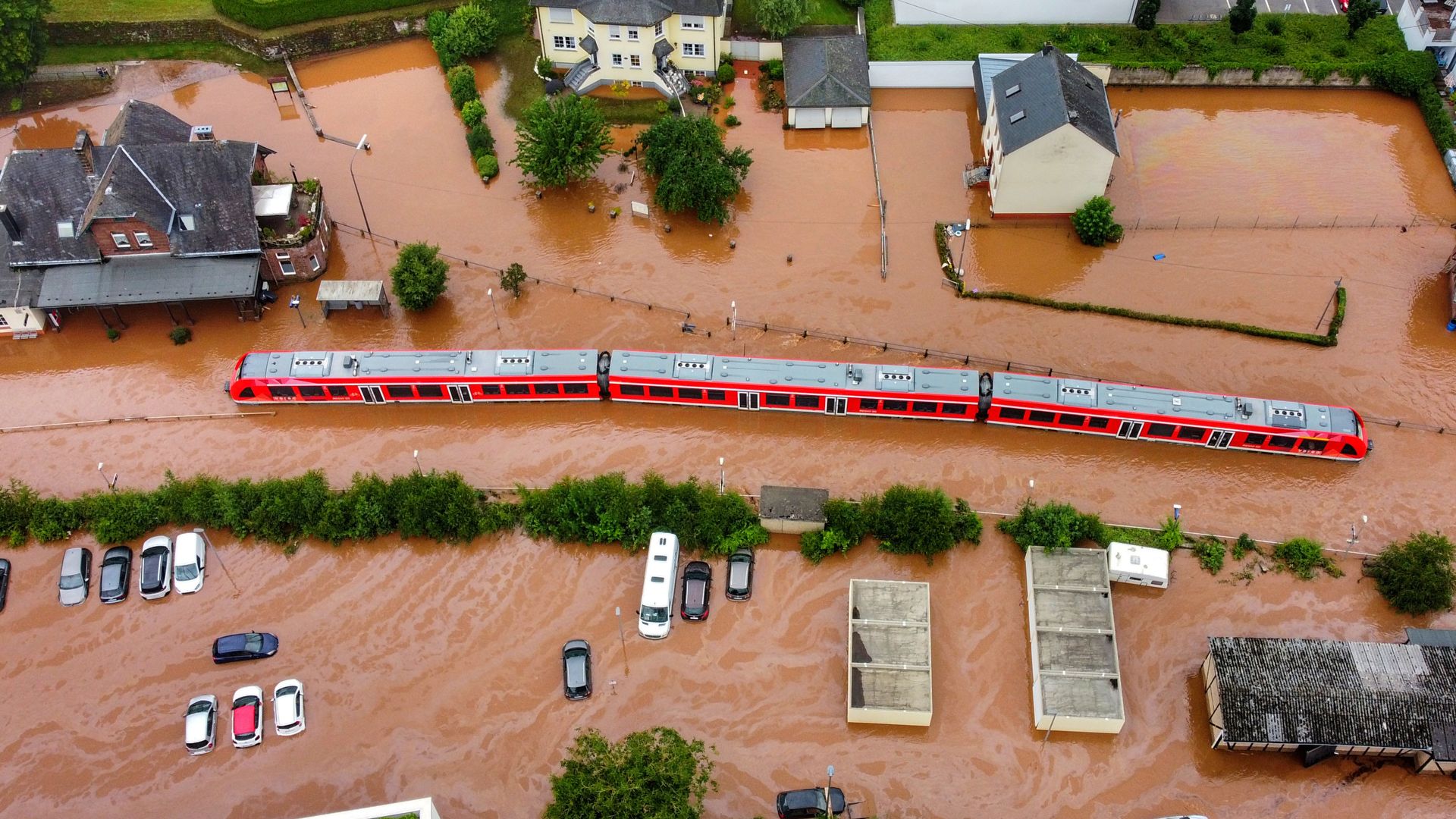 An aerial shot of a train partially submerged under flooding.