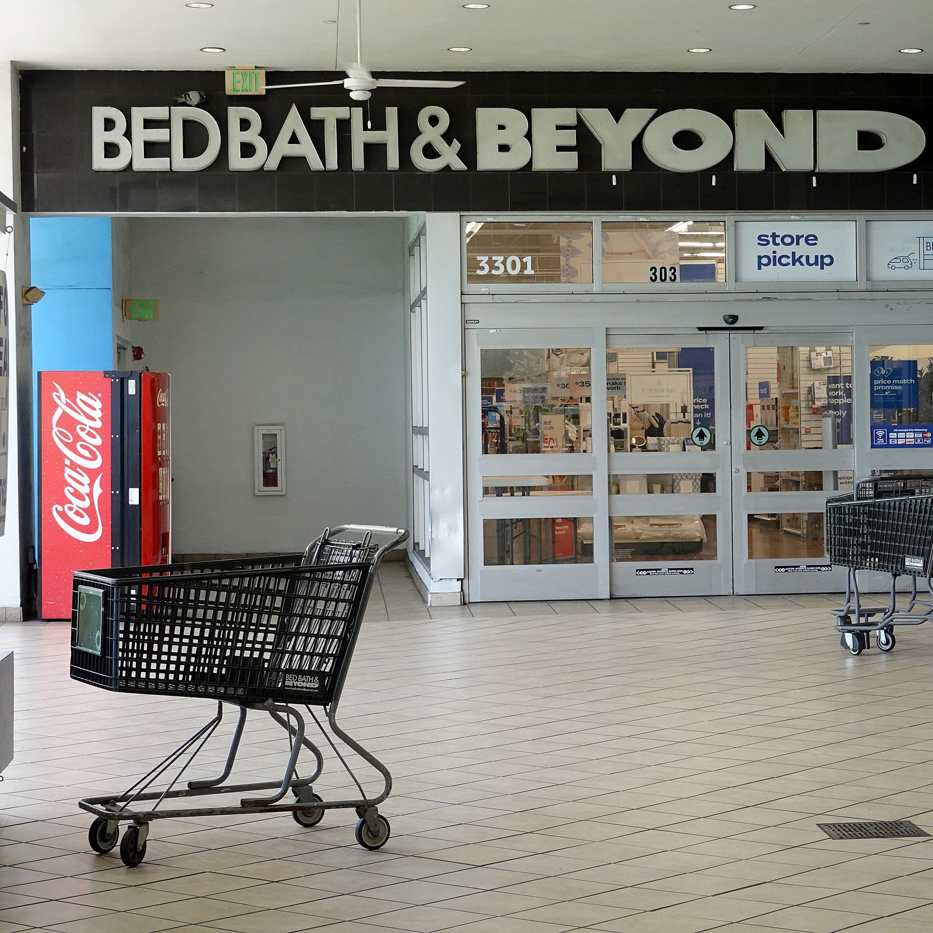 An empty shopping cart sits in front of retailer Bed Bath & Beyond's store entrance.