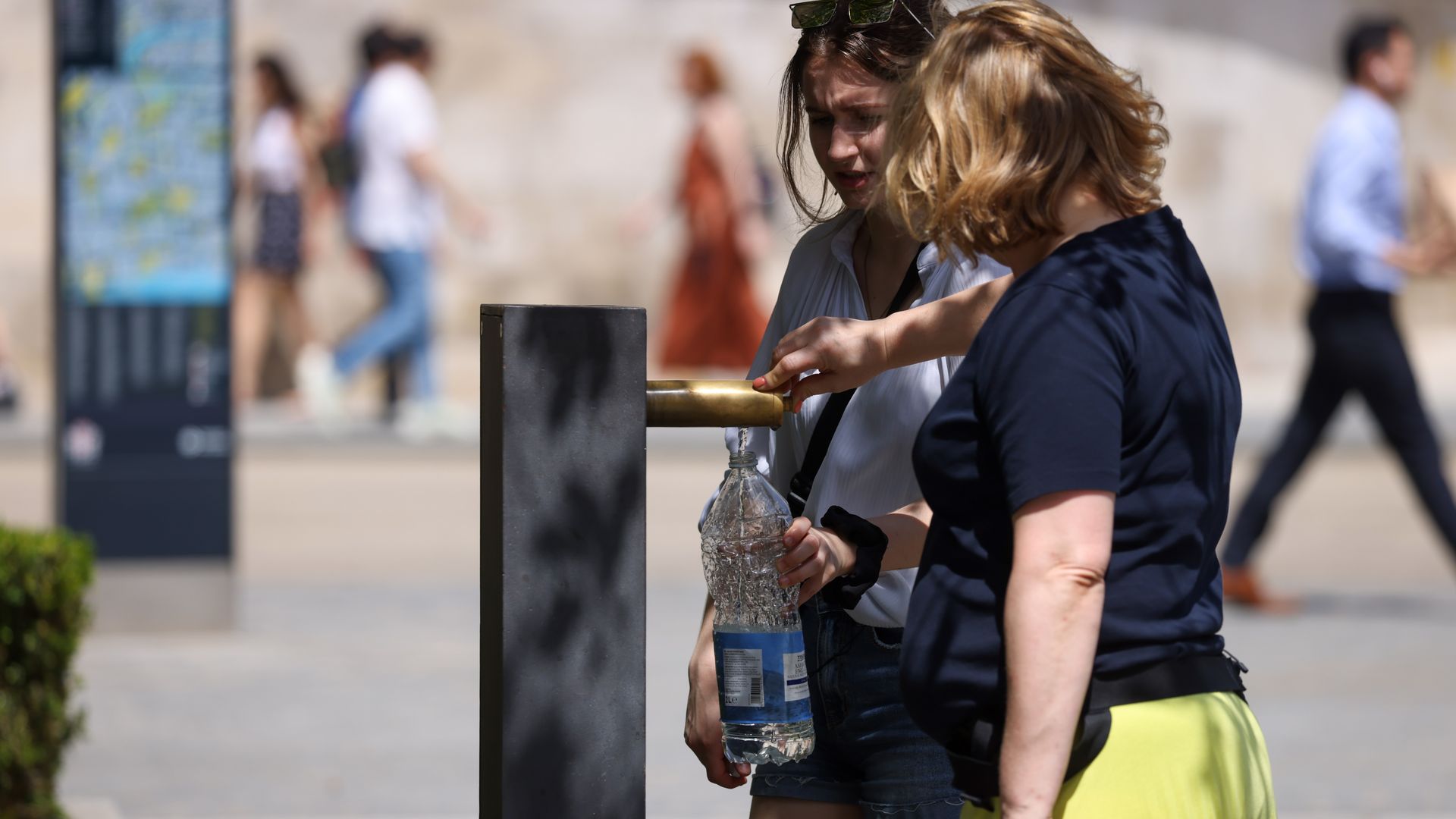 Pedestrians fill up a water bottle in June of this year as tepertarues reach 34 degrees Celsius (93.2 degrees Fahrenheit)