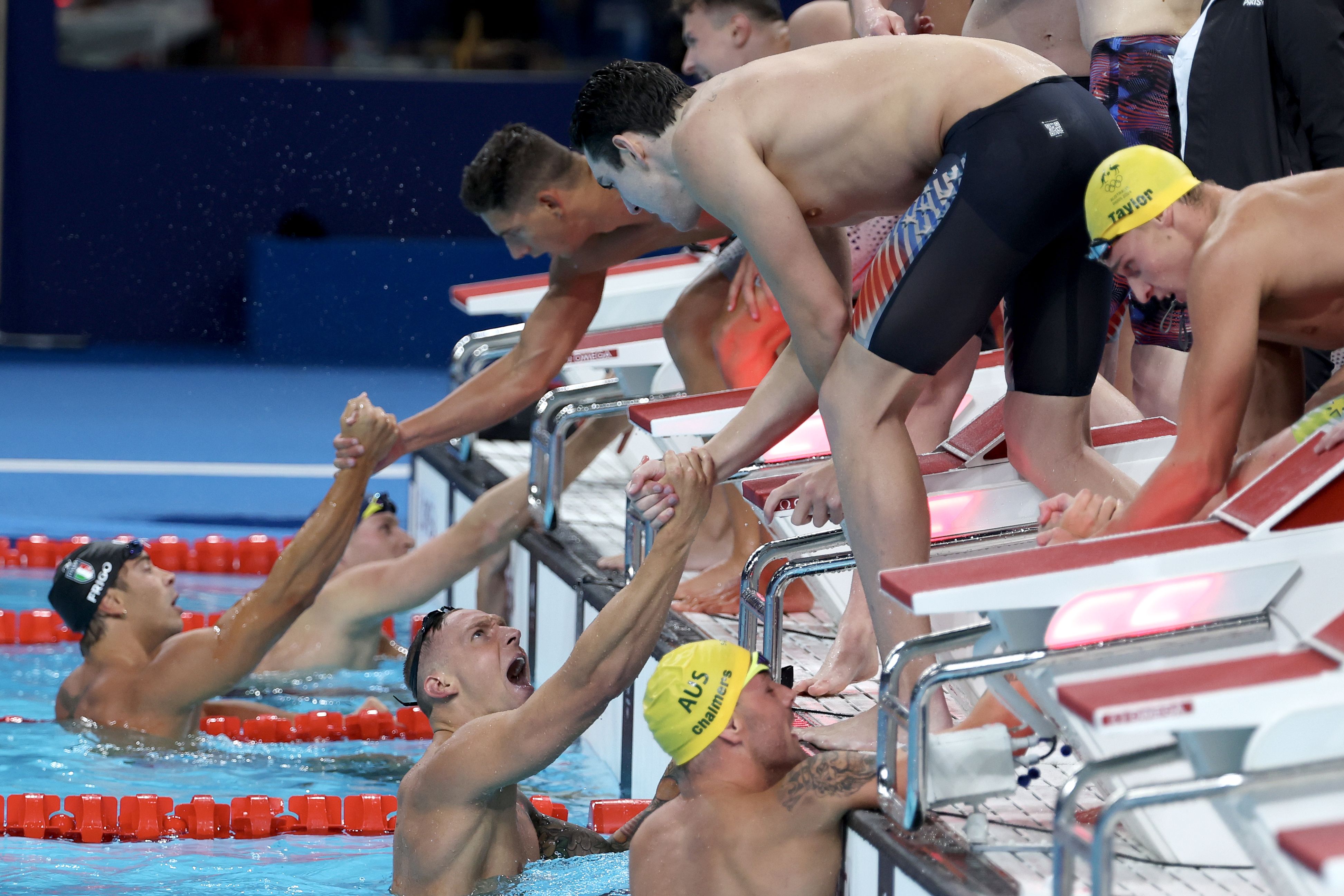 Caeleb Dressel and Jack Alexy of Team United States celebrate after winning gold in the Men's 4x100m Freestyle Relay Final on day one of the Olympic Games Paris 2024 at Paris La Defense Arena on July 27, 2024 in Nanterre, France. 