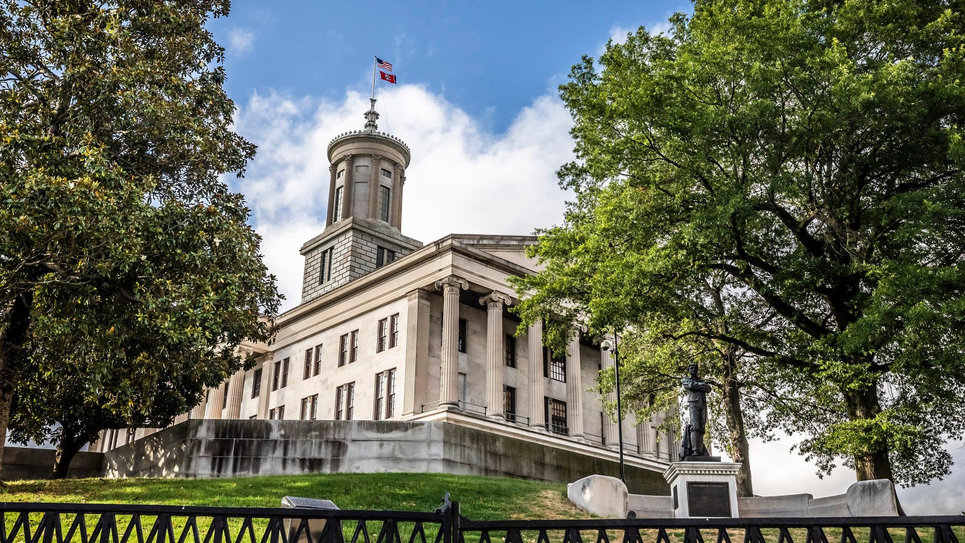A photo of the exterior of the Tennessee Capitol surrounded by leafy trees
