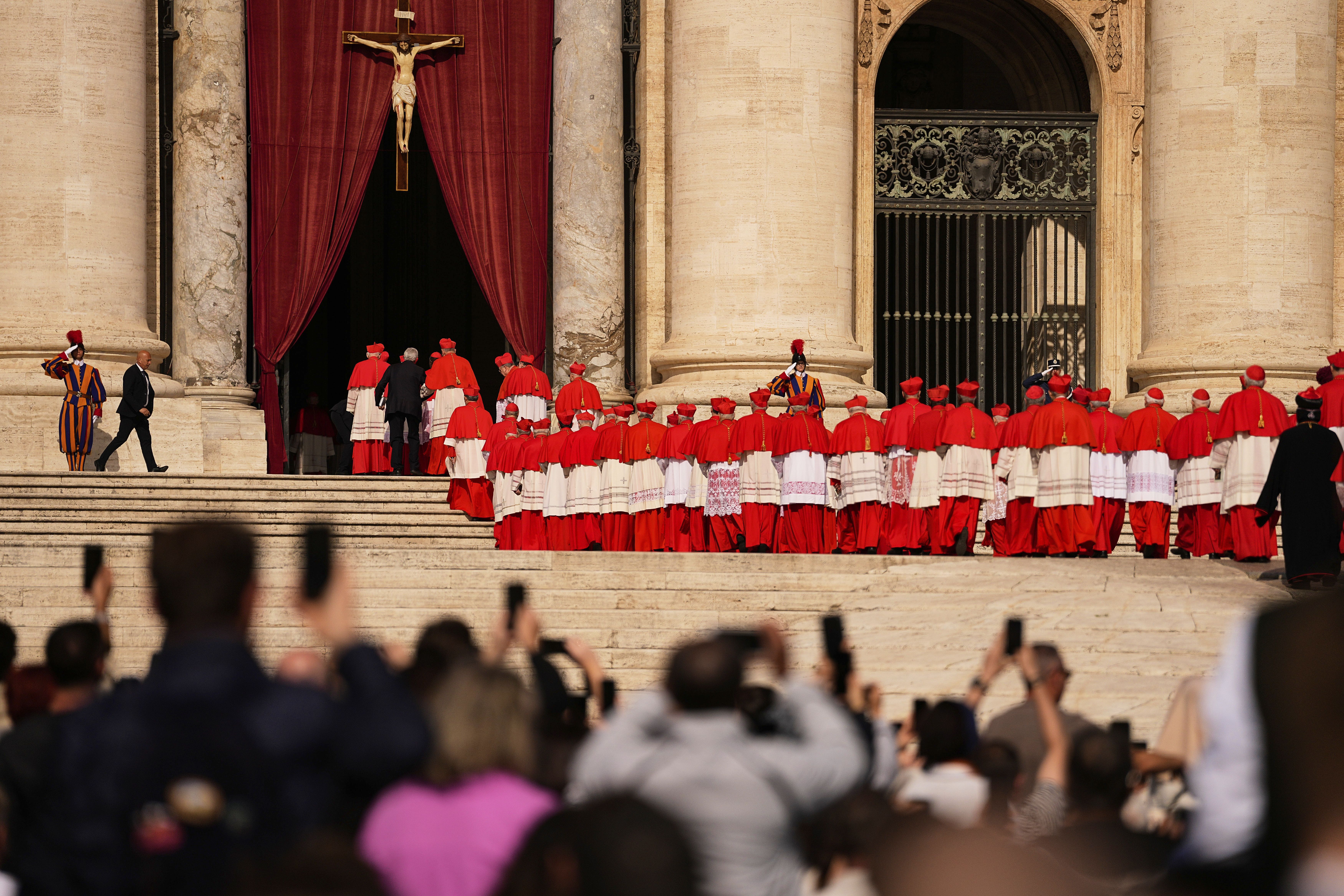 Cardinals walk through St. Peter's Square ahead of the coffin