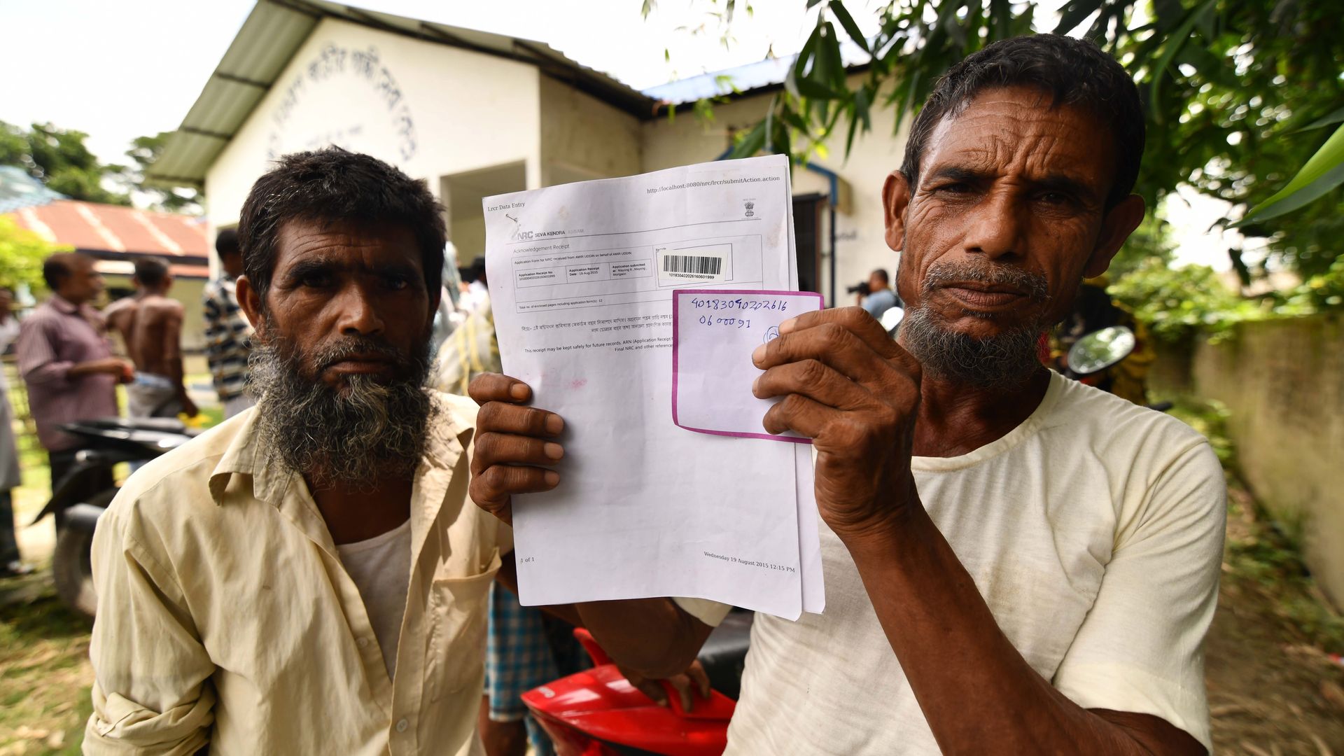 Resident of Assam holding up his citizenship papers