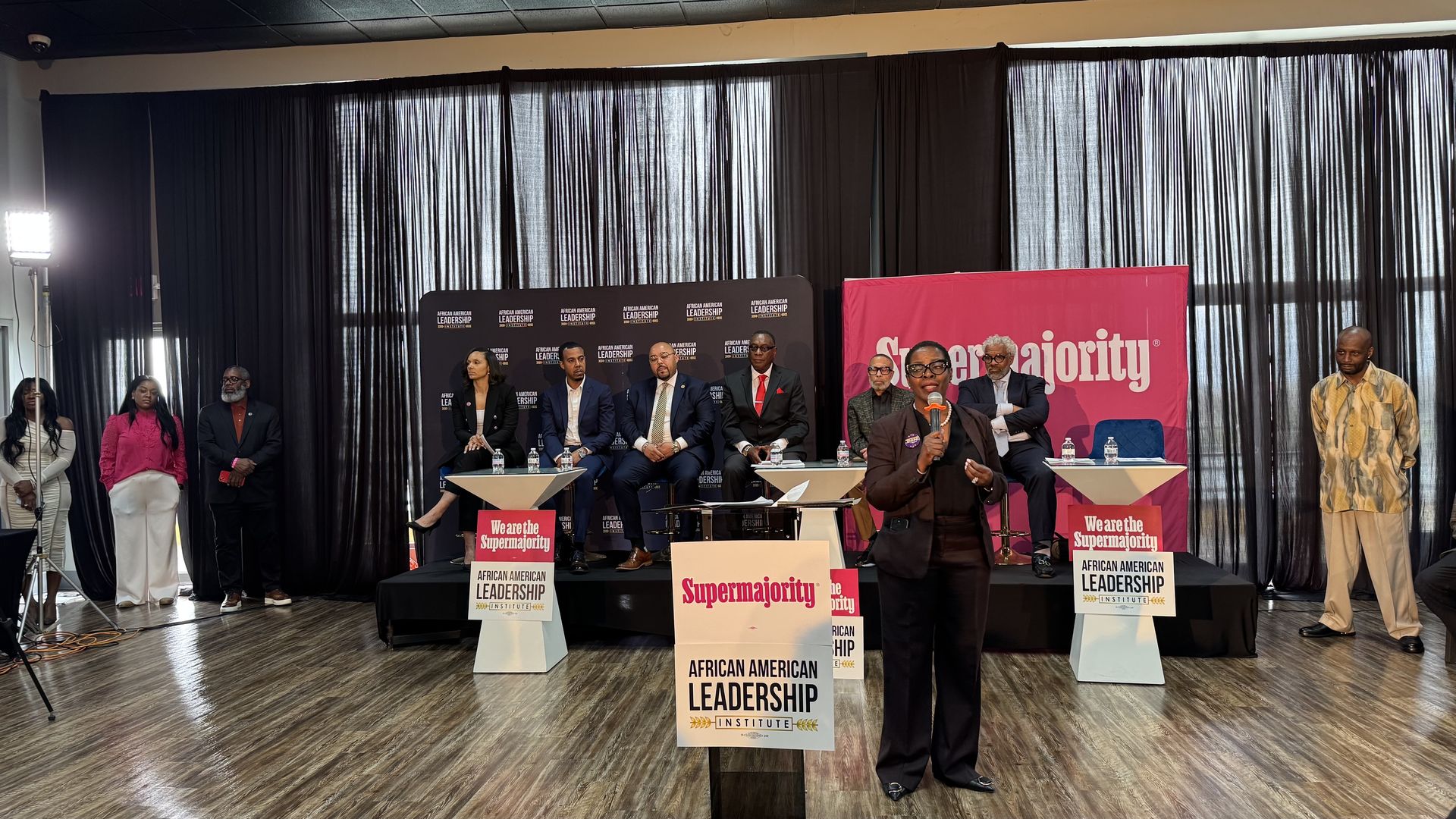 The candidates stand on stage.