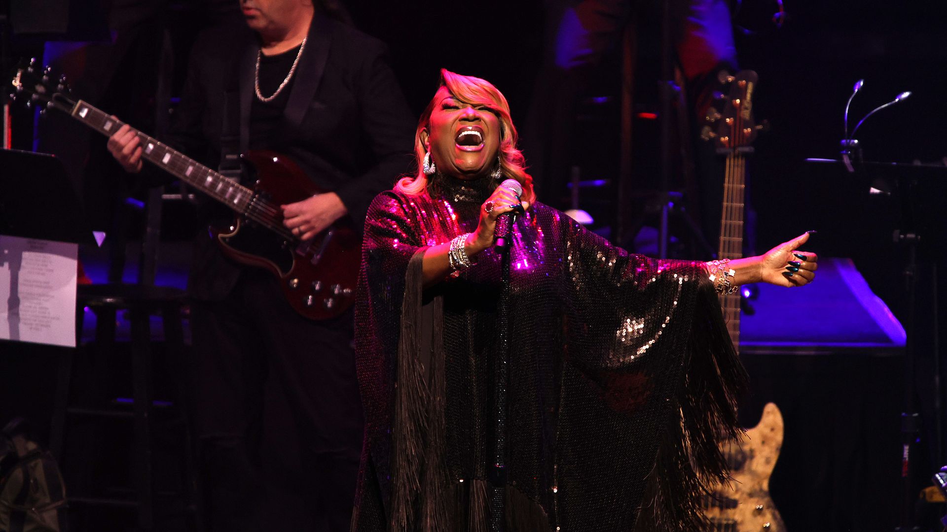 a woman singing on stage with a mic