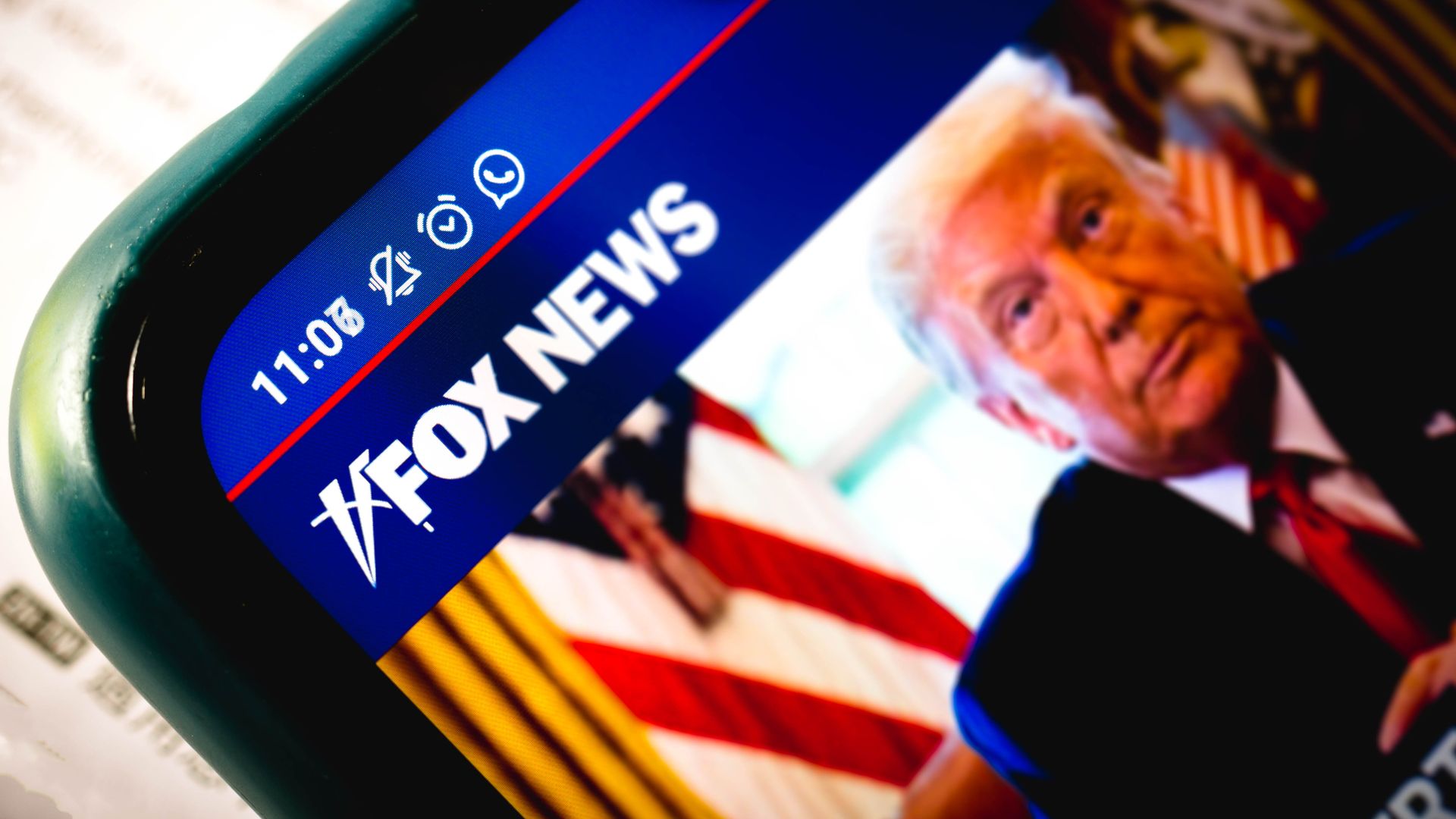 Photo of a phone screen showing the Fox News website and a picture of Donald Trump