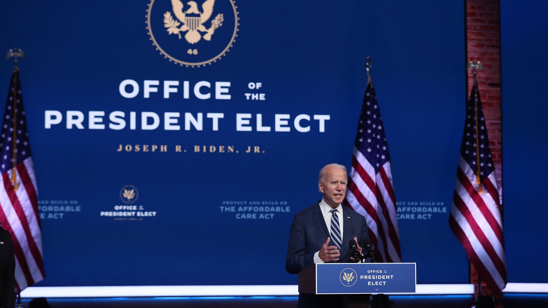 A photo of Joe Biden standing at a lectern to give an address, with "Office of the President Elect" in large lettering behind him