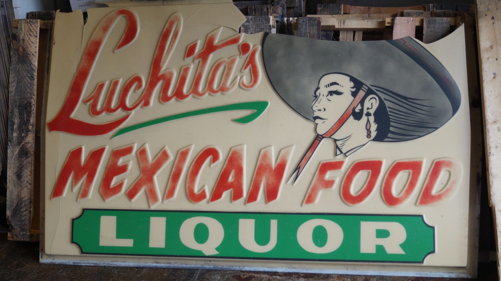 The chipped sign for Luchita's Mexican restaurant, removed and on the cement floor of a neighboring business.