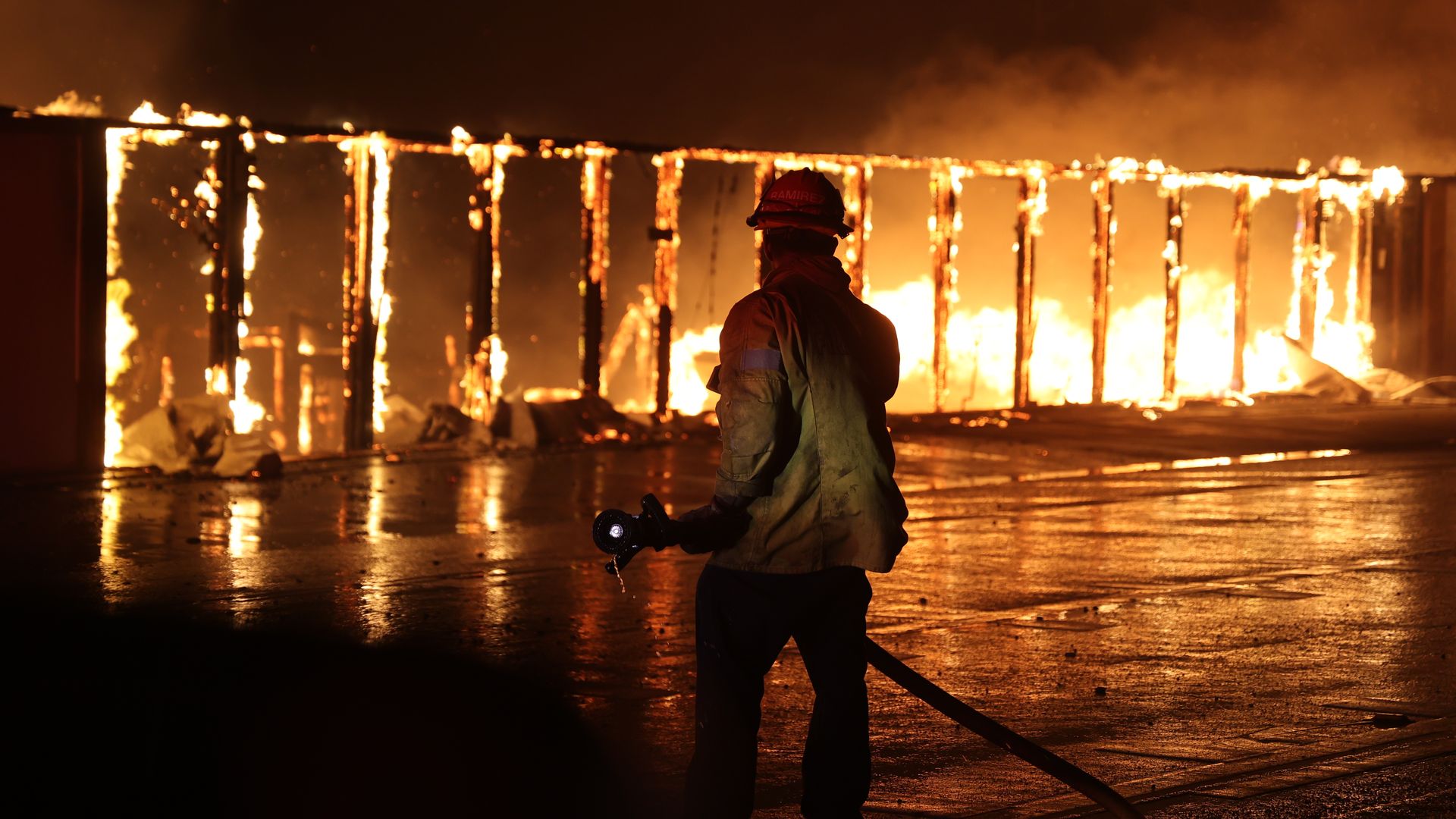 Firefighter standing in front of a blaze