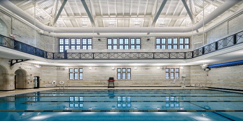 An indoor swimming pool with lane makers and white walls around it. 