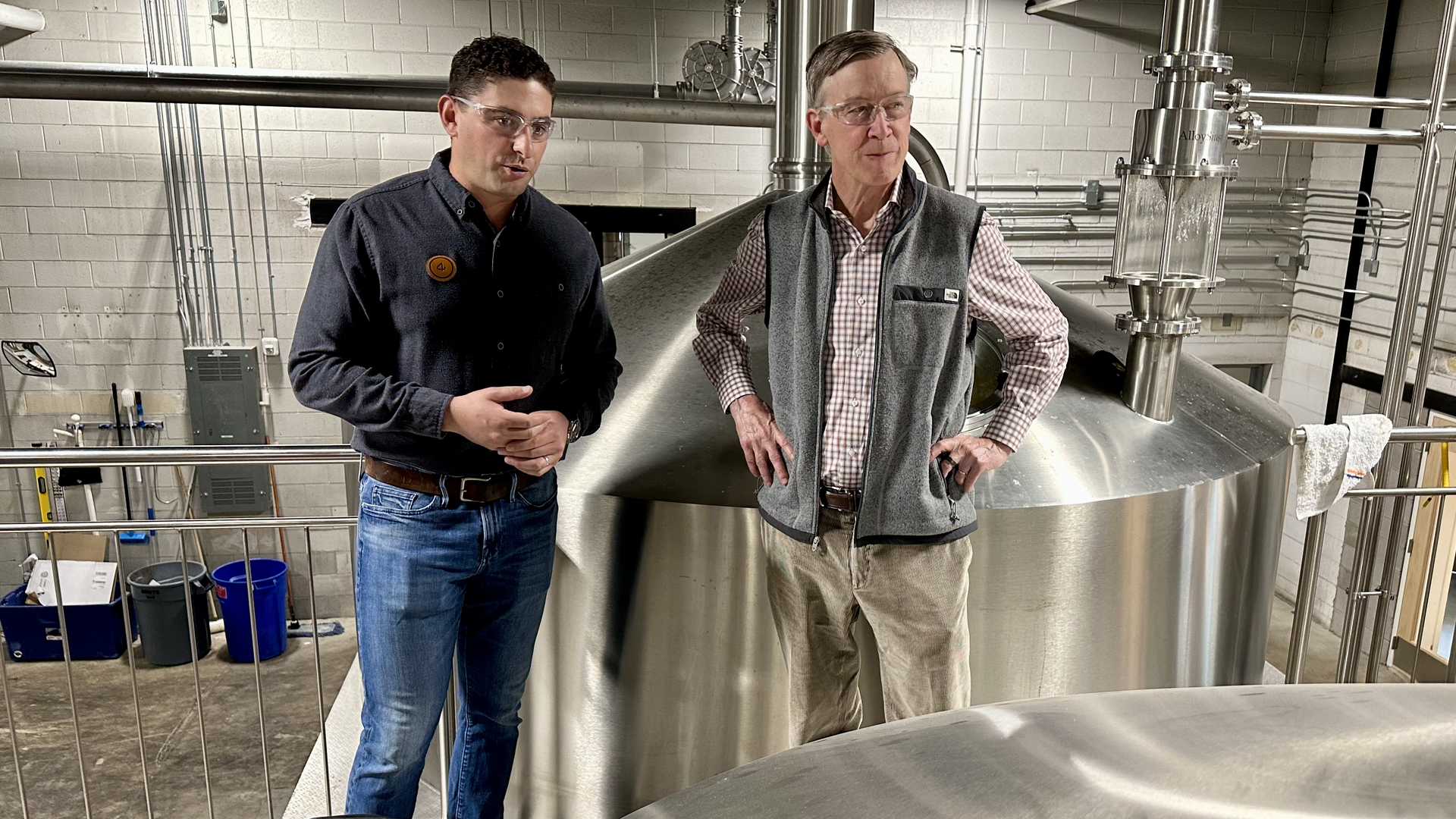 Tommy Bibliowicz, left, co-owner of 4 Noses Brewing, shows U.S. Sen. John Hickenlooper, right, the brewing process at the company's Park Hill location Tuesday. Photo: John Frank/Axios