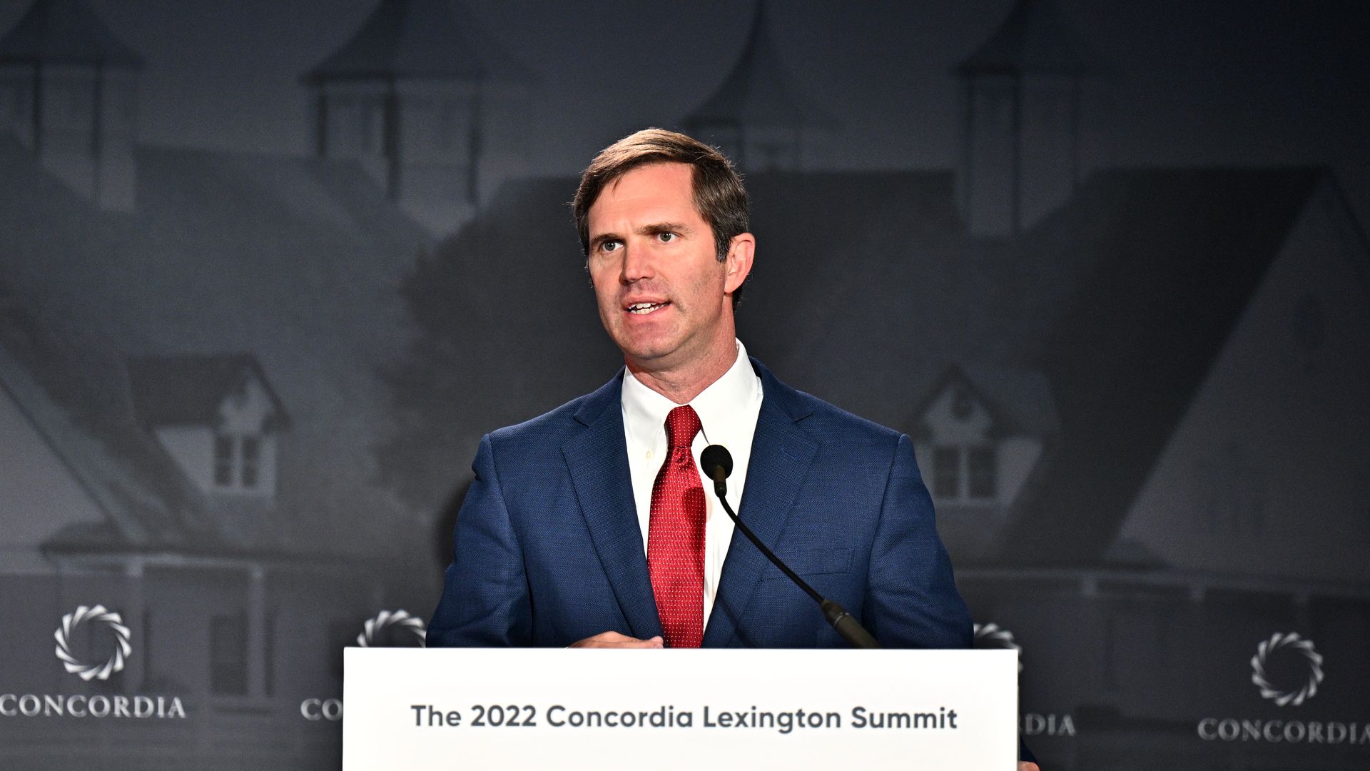 Photo of Andy Beshear speaking at a podium in a suit