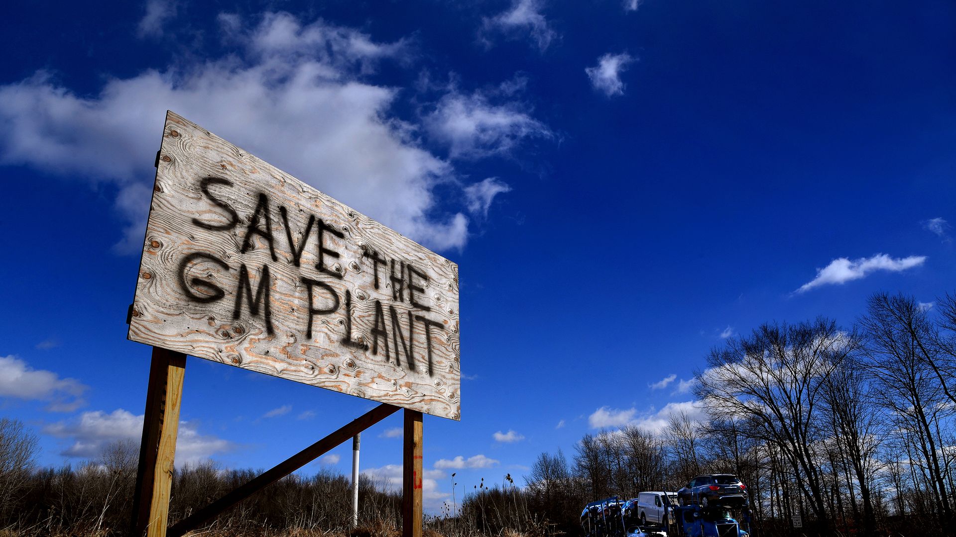Photo of a stark wooden sign planted on ground in Lordstown, Ohio, saying "Save the GM Plant"