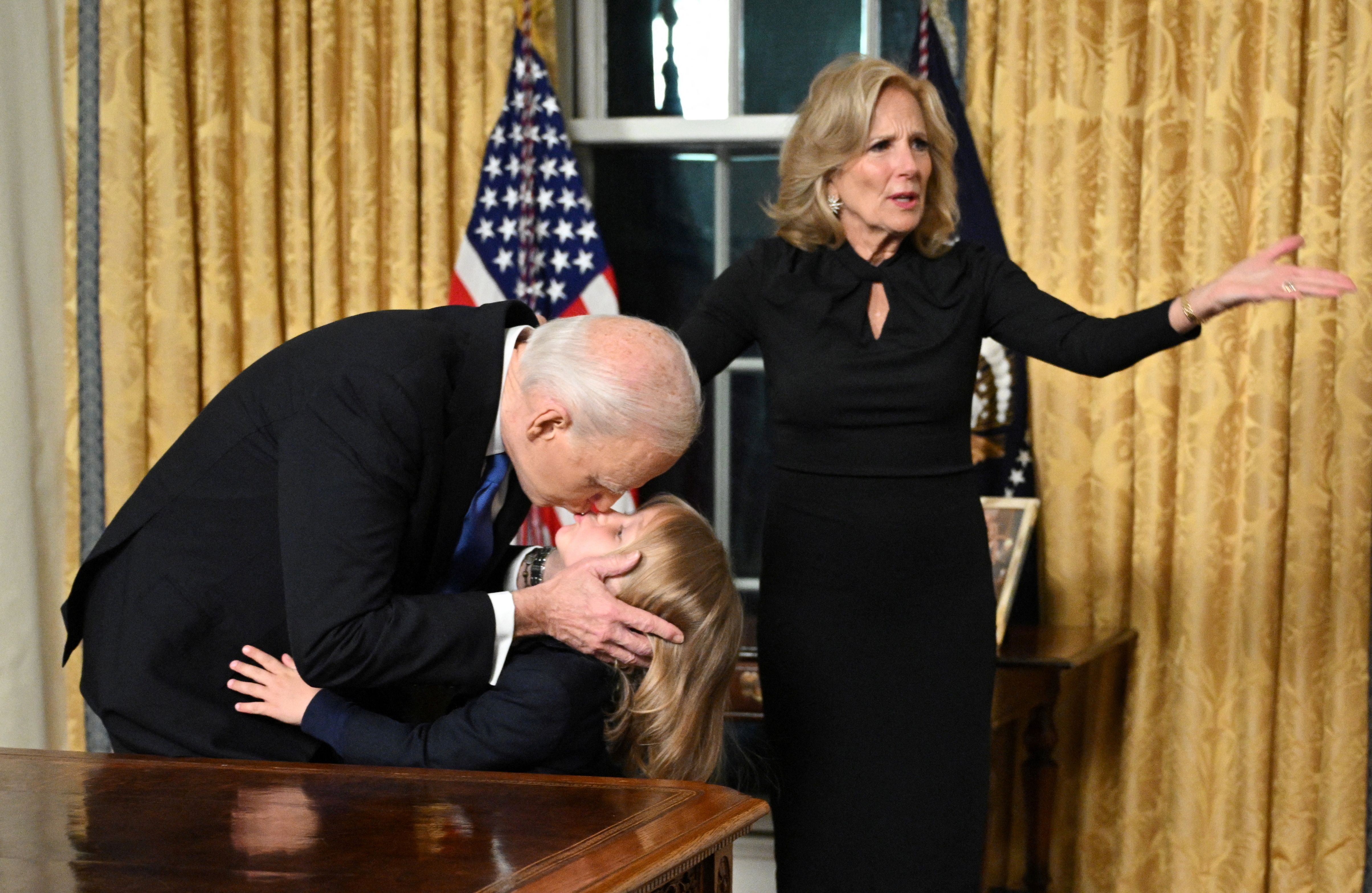 US President Joe Biden kisses his grand-son Beau Biden Jr. as First Lady Jill Biden gestures 