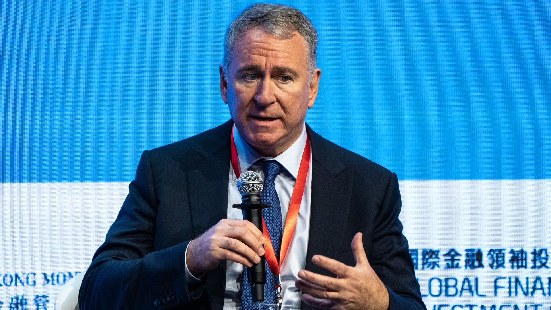 Ken Griffin holds microphone while speaking at a summit in Hong Kong